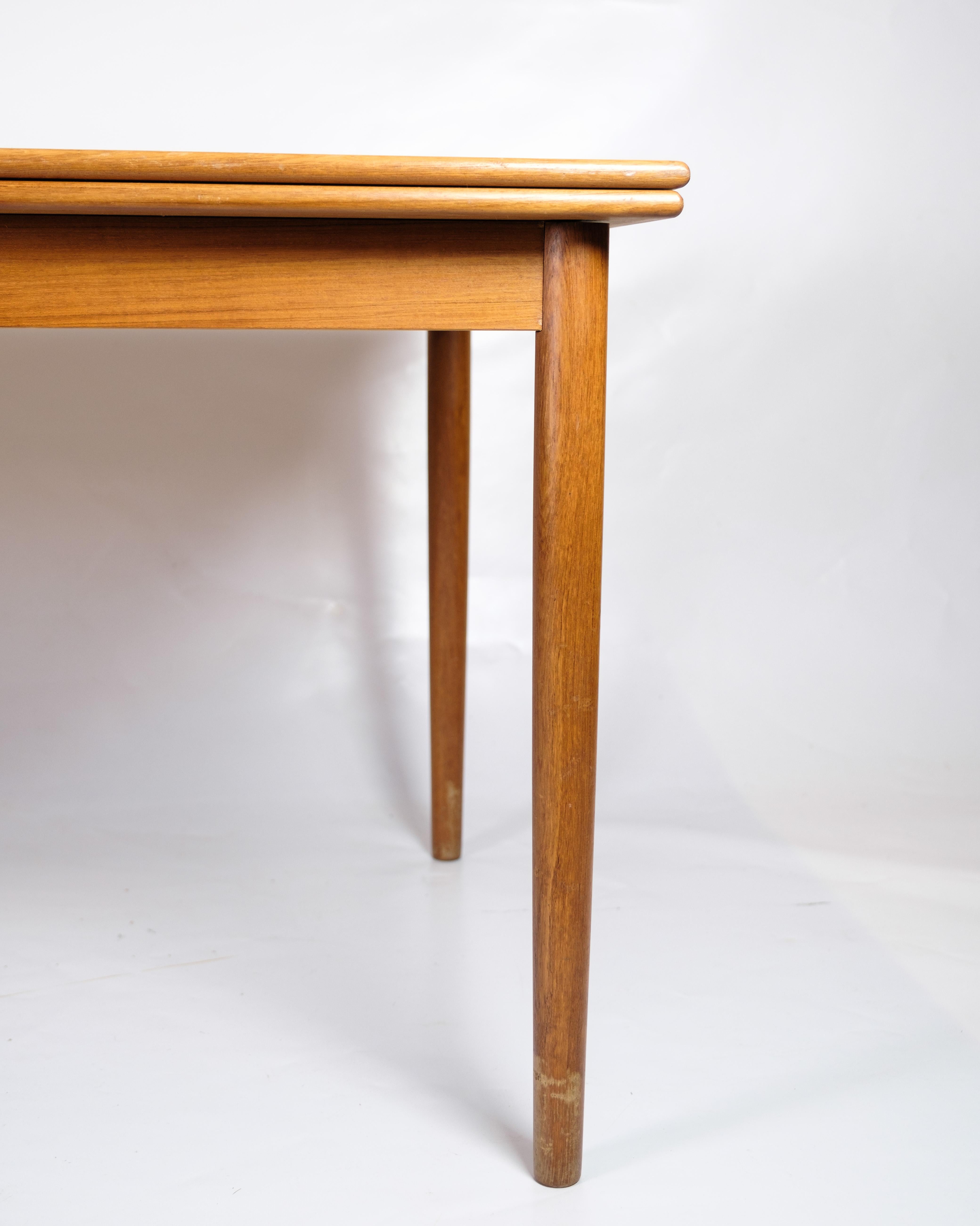 Extendable dining table from the 1960s, made of teak and Danish design. The table is designed with clean lines and a robust construction, typical of the period. It has an extension function that allows you to add extra leaves and thus extend the