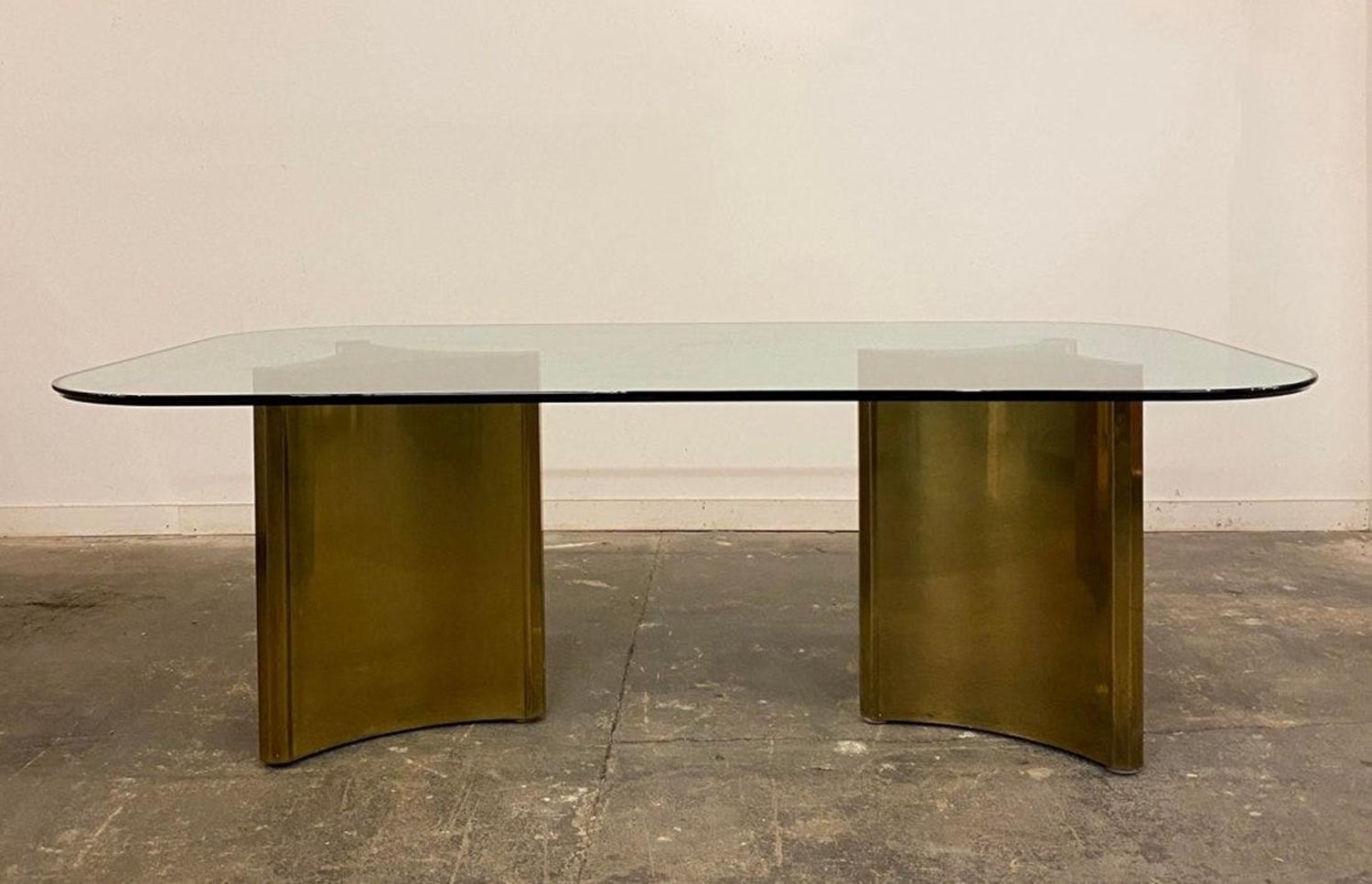 Dining table with 2 brass pedestals by mastercraft.
The table has a large glass table top that is 3/4 of an inch thick, the brass has a nice aged patina and shows beautifully though the glass.
The dimensions of the pedestals from point to point is