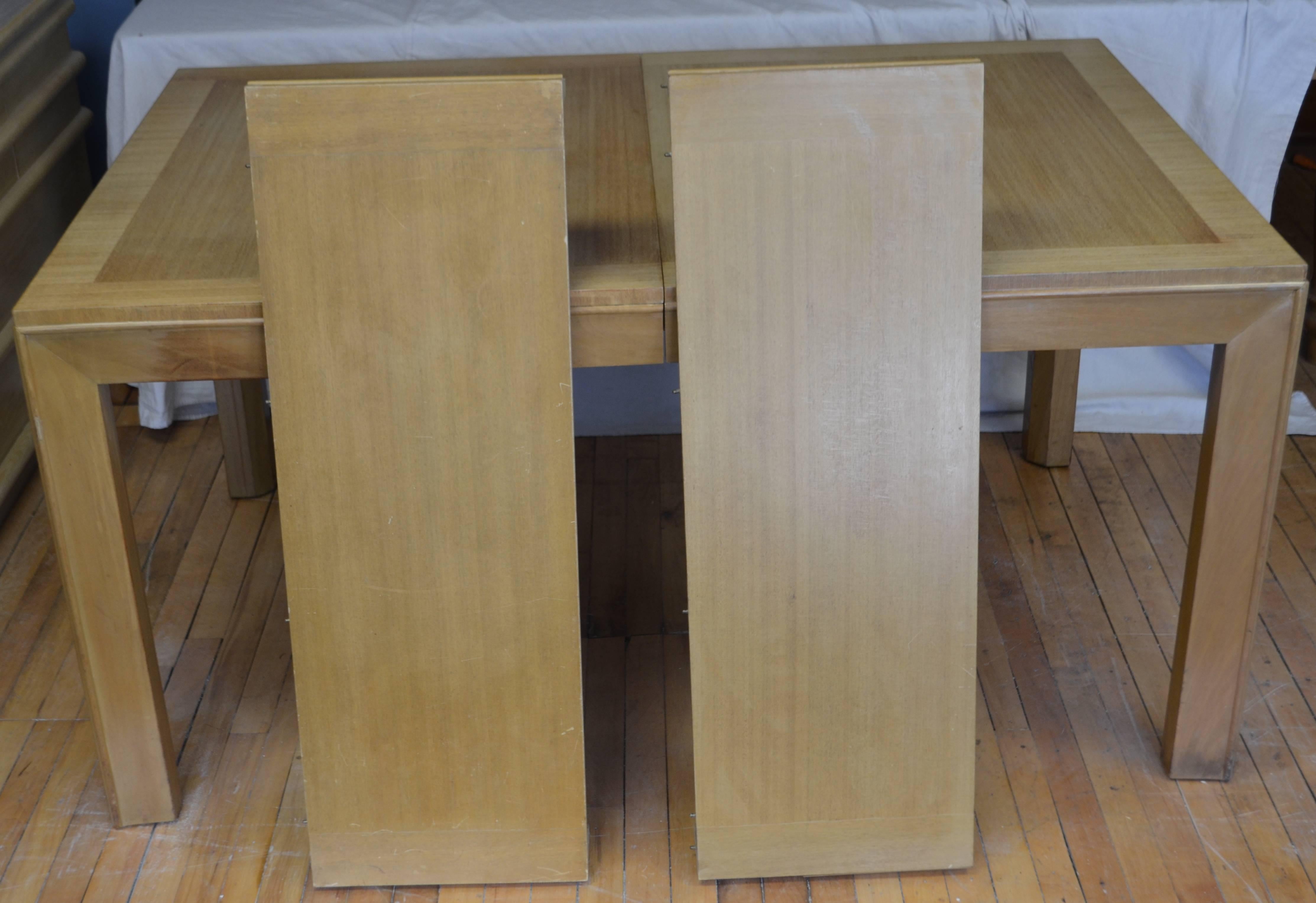Dining table of blonde maple with two leaves designed by Robsjohn-Gibbings for Widdicomb, circa 1948. Top has been refinished. Dimensions listed below are with two leaves in the table. Dimensions without the leaves are: 60 inches wide.