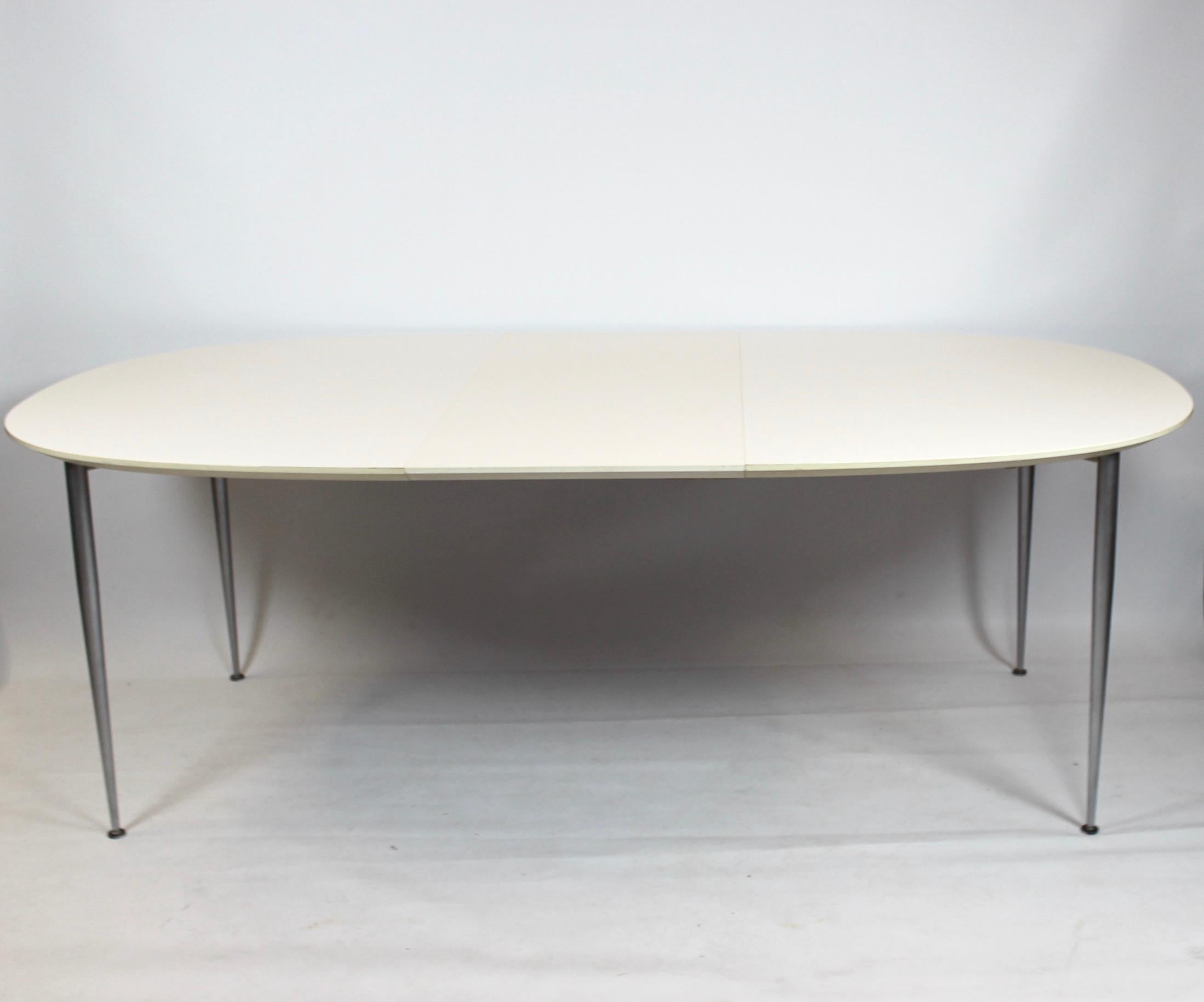 Dining table with white laminate and steel legs of Danish design. The table is in great vintage condition and comes with two extension plates including a fifth leg for support.
   