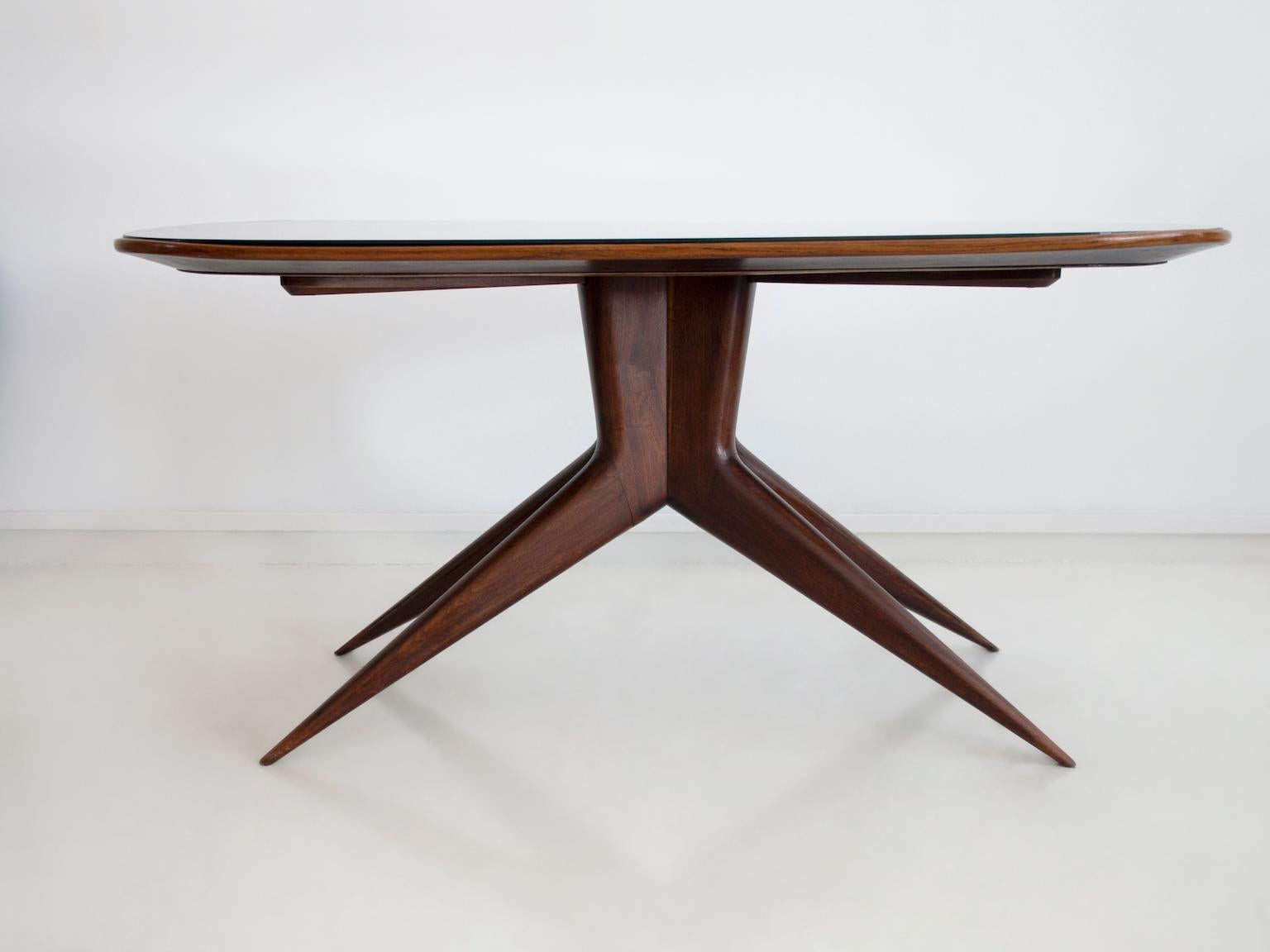 Rectangular dining table with round corners, manufactured in Italy, circa 1950. Structure made of wood, slender legs, top of dark stained crystal.