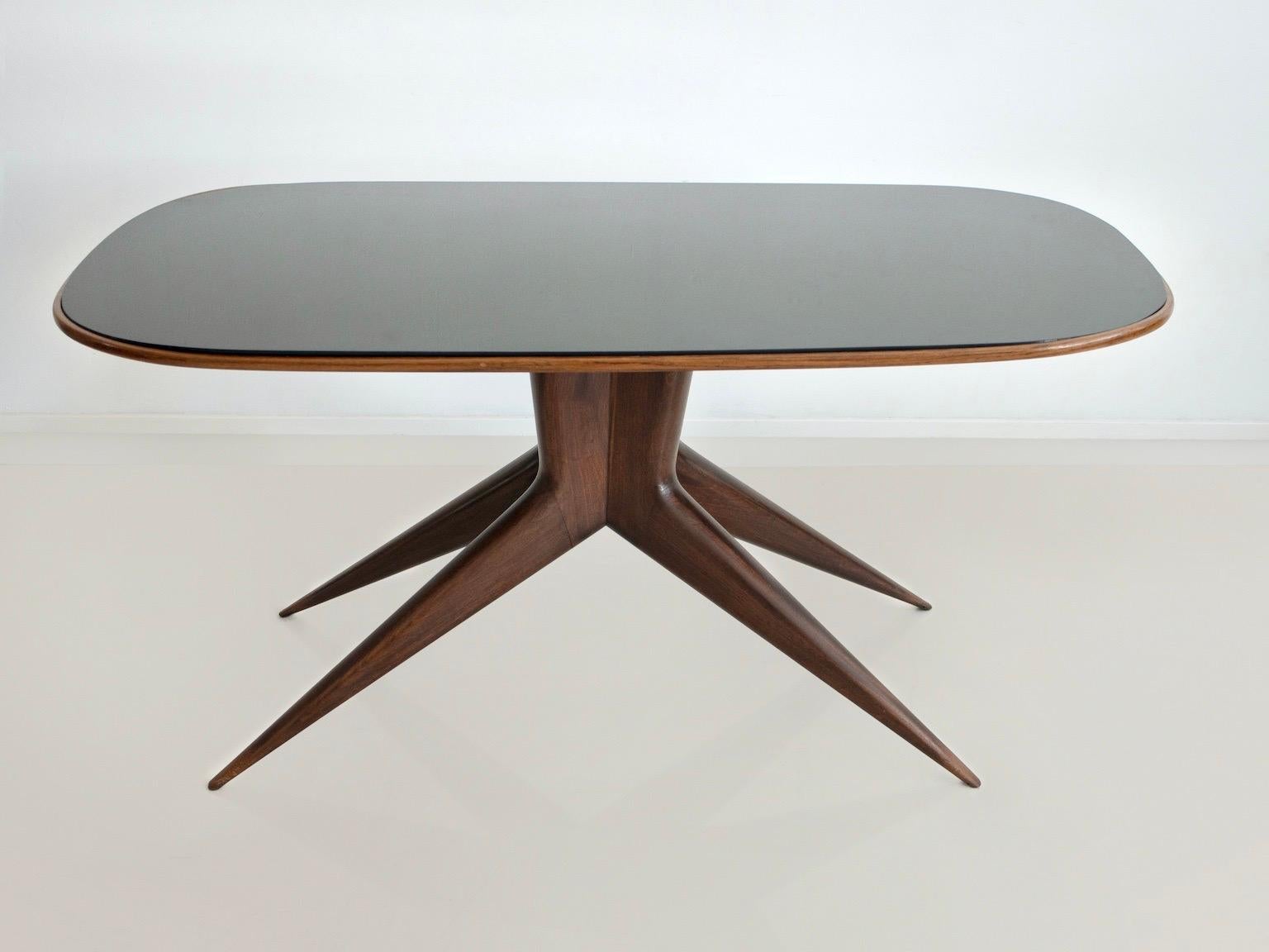 Table de salle à manger rectangulaire aux coins arrondis, fabriquée en Italie, vers 1950. Structure en bois, pieds élancés, plateau en cristal teinté foncé.