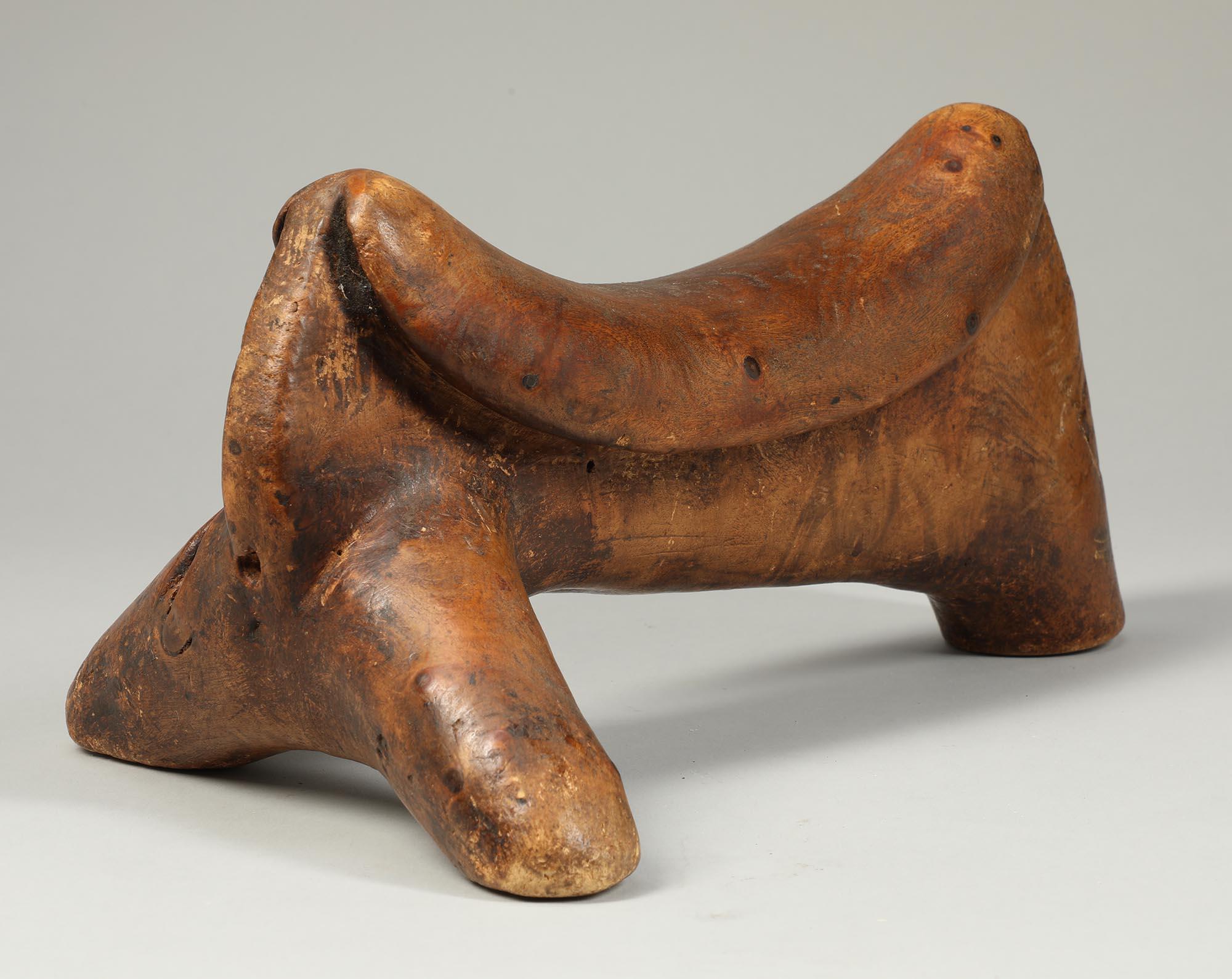 Dinka stylized animal form carved wood headrest, East Africa.  On three 