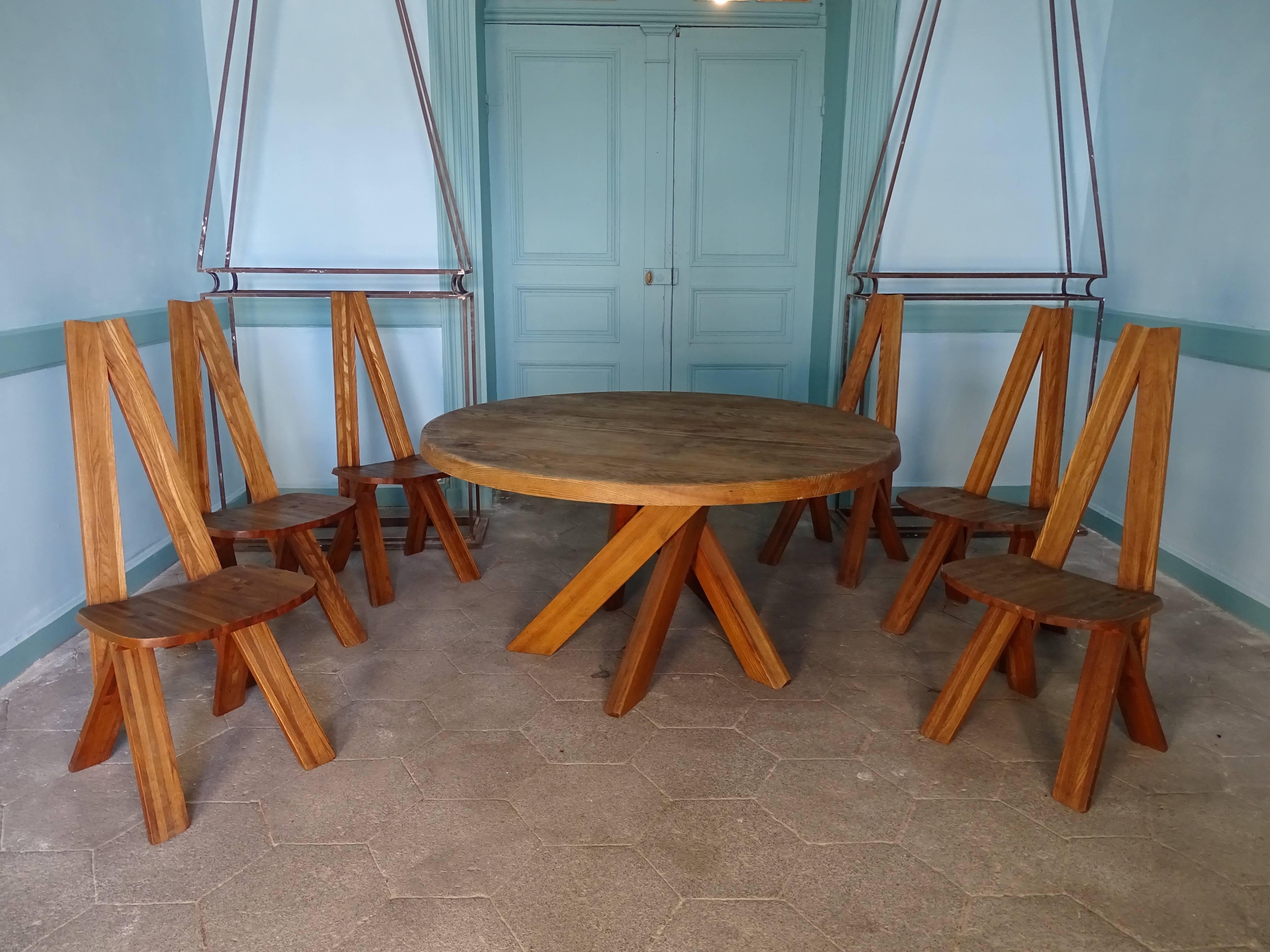 Incredible dining table designed by Pierre during the 1960. The set is composed of one big dining table model T21 or Sfax, and a set of six elm chairs, model S45. The table is composed of a circular top with a thickness of 7cm on a base made of five