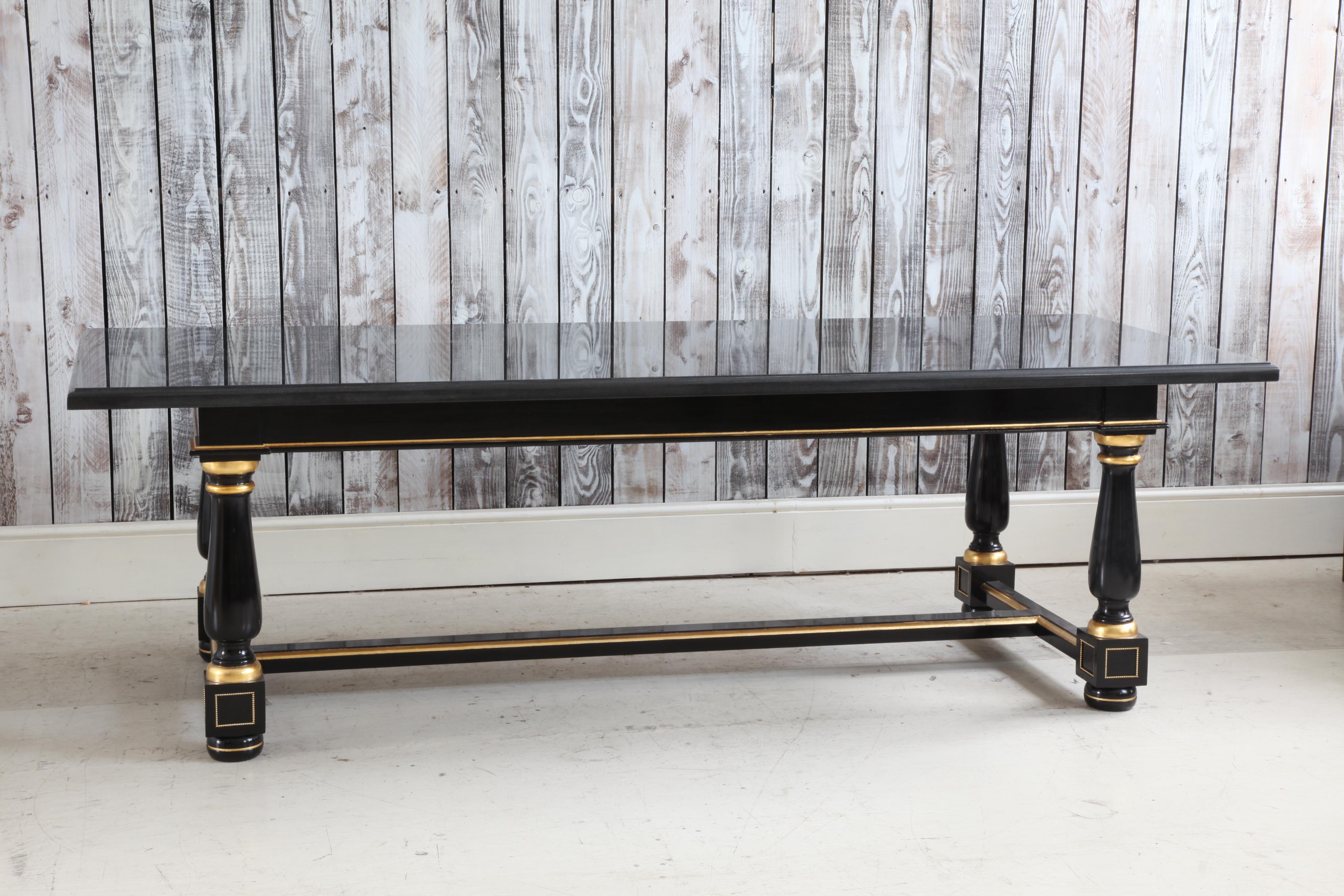 Wooden dining table finished in a black Lacquer with gold highlights and ormolu pearls on the feet.
The top is a 30mm Nero Assoluto polished granite.
 