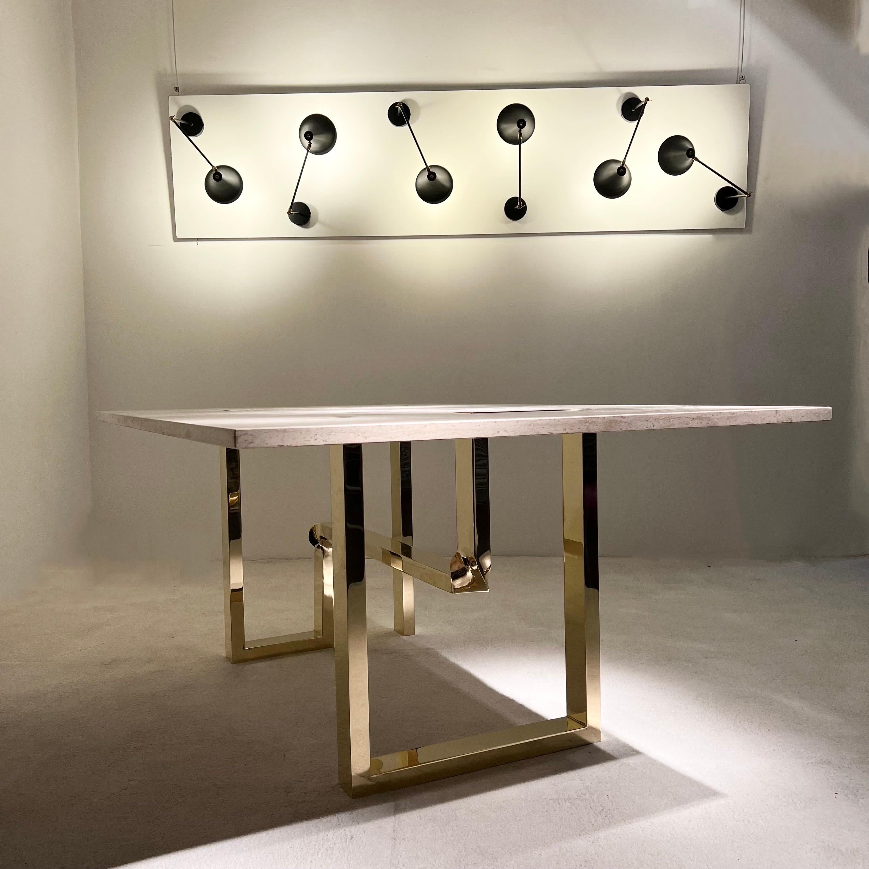 Table à manger d'Alfredo Freda pour Cittone Oggi, construction sculpturale avec une base en laiton torsadé supportant un plateau rectangulaire en travertin.