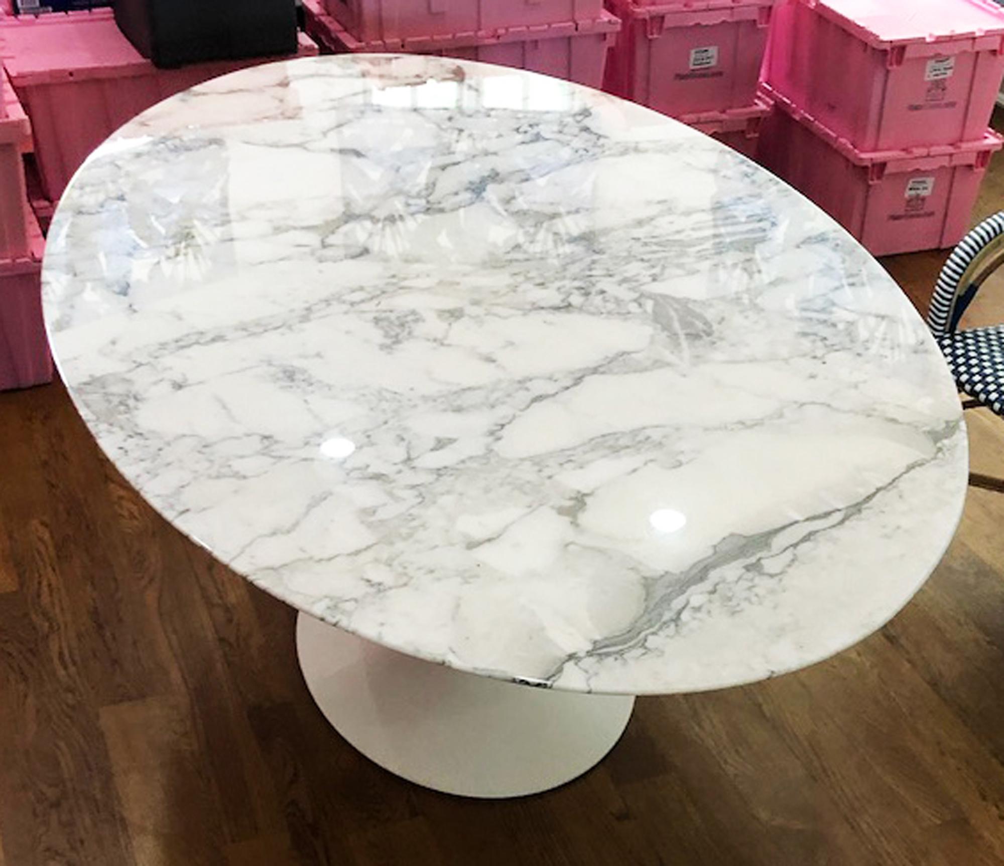 Oval marble dining table-white this table's organic shape and timeless form has become a symbol of modernism for over the past 60 years. 
An authentic Eero Saarinen Tulip table in great used condition. 
Cast aluminum pedestal powder coated in