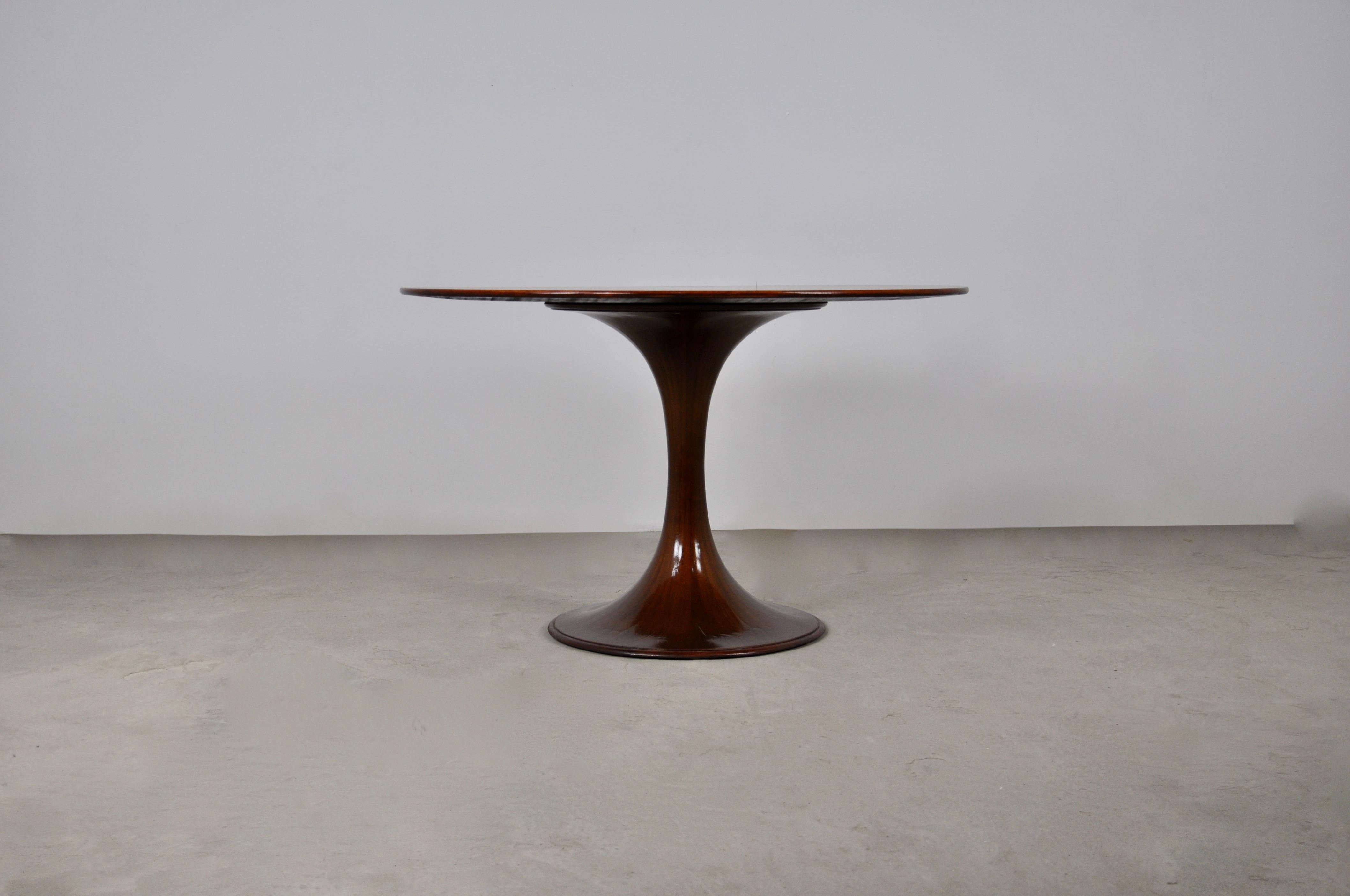 Round wooden table from 1959 with round leg. Wear due to time and age of the table.
 