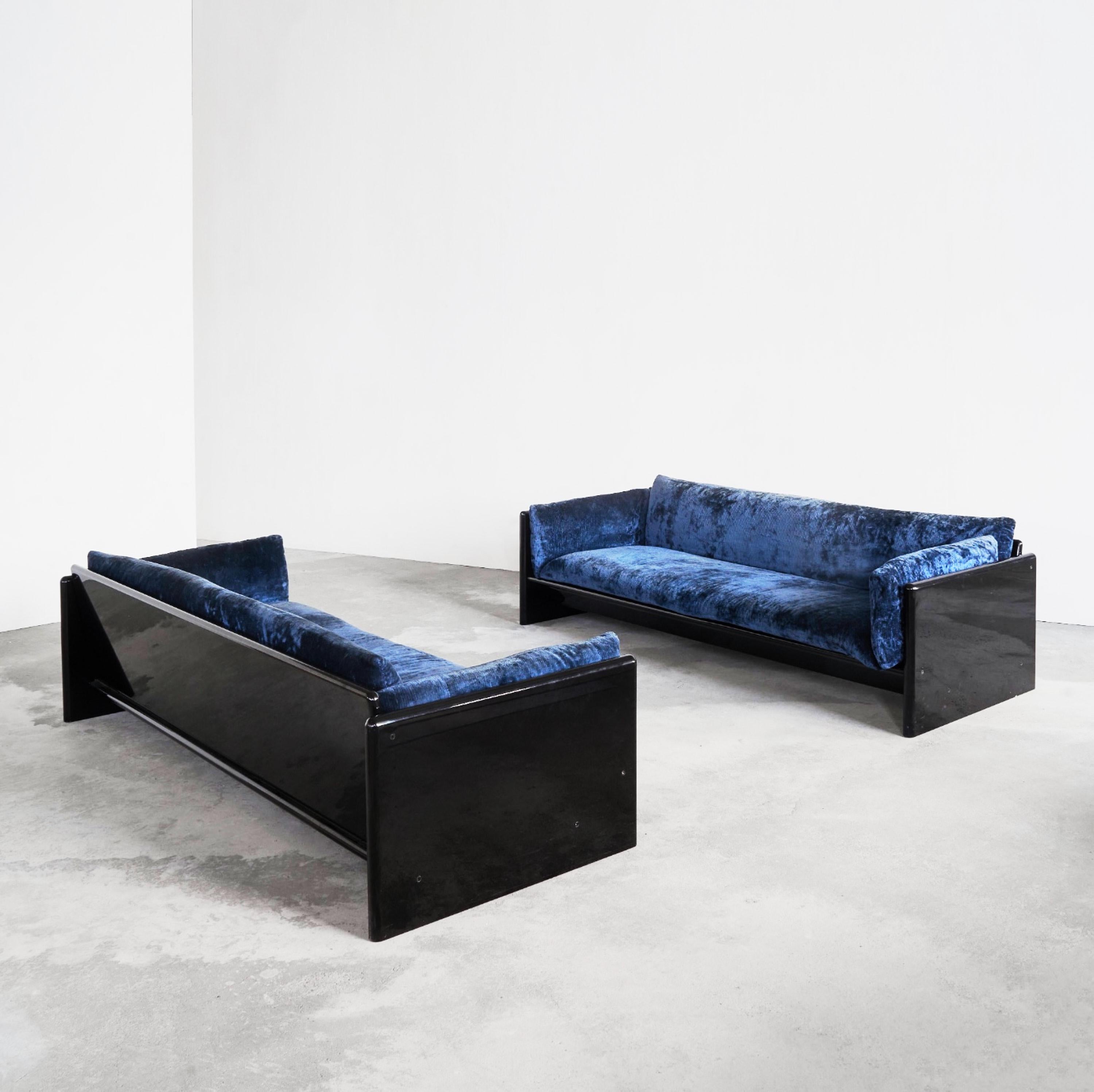 Dino Gavina (1922-2007) rare pair of blue velvet 'Simone' sofas for Studio Simon 1971. Black lacquered high gloss wooden frame and blue velvet upholstery. 

Striking pair of sofas with a black lacquered high gloss wooden frame and the original