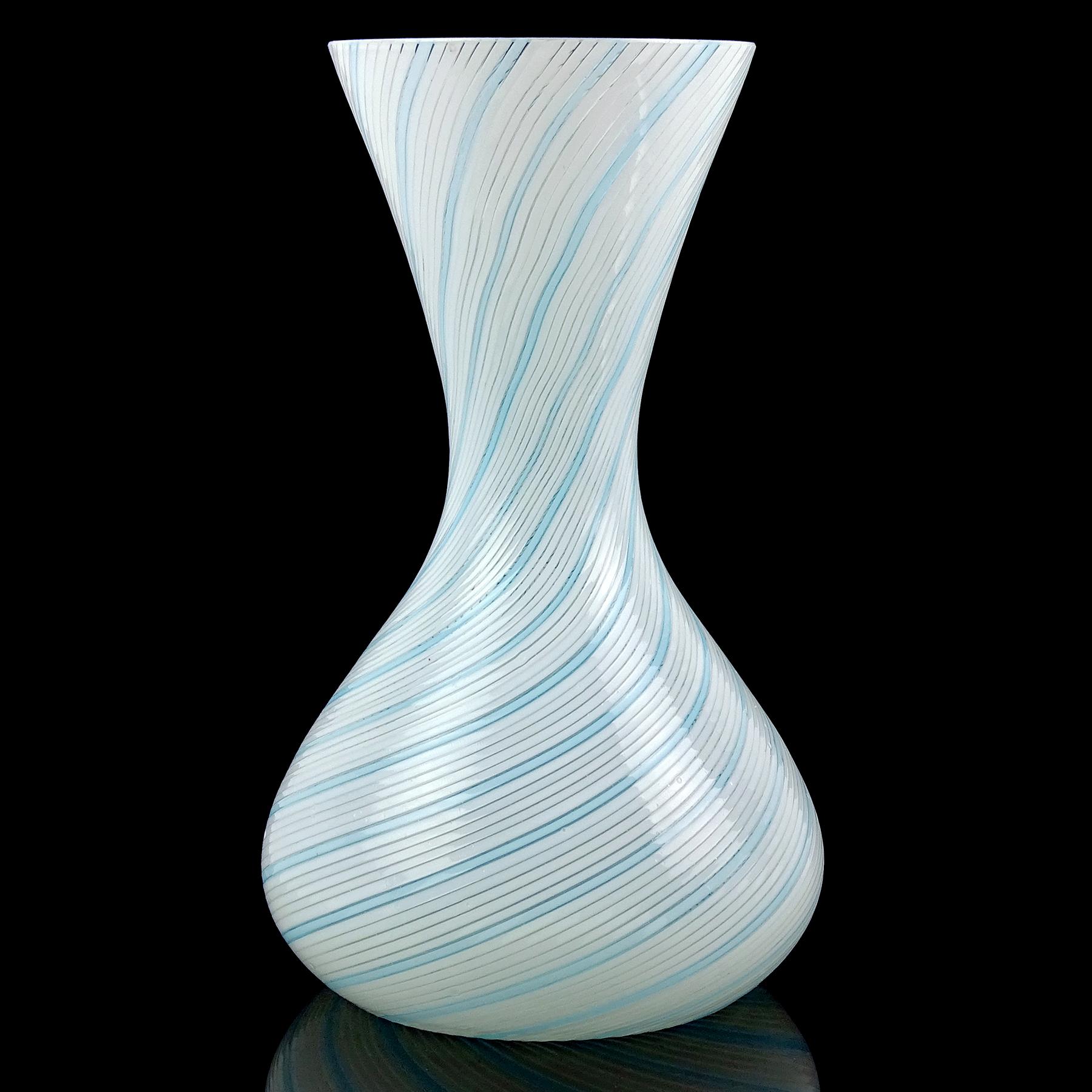 Beautiful vintage Murano hand blown white and blue ribbons Italian art glass flower vase. Documented to designer Dino Martens for Aureliano Toso. The vase is created in the “Mezza Filigrana” technique, with 5 rows of white and 1 row of sky blue