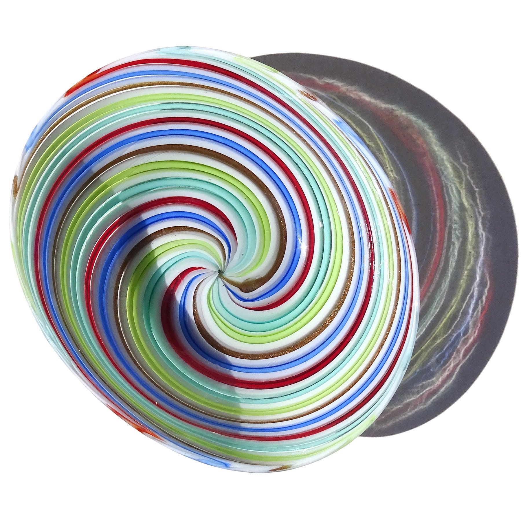 Beautiful vintage Murano hand blown red, pink and blue ribbons Italian art glass dish. Attributed to designer Dino Martens for Aureliano Toso. The swirling ribbons have an alternating pattern, creating an optic effect. It also have a line with