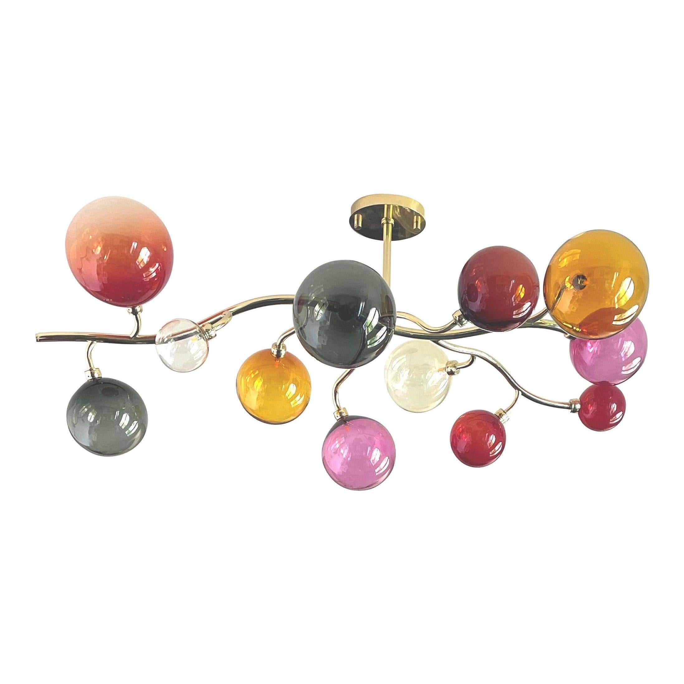 Dionysos chandelier by Emilie Lemardeley
Polished brass and hand blown glass spheres
Handmade in France, 21st century. 
Glass colors: fuchsia, dark and light red, grey, light amber, champagne

Measures: Width: 47.24 In
Deep: 23.62 in
Height: