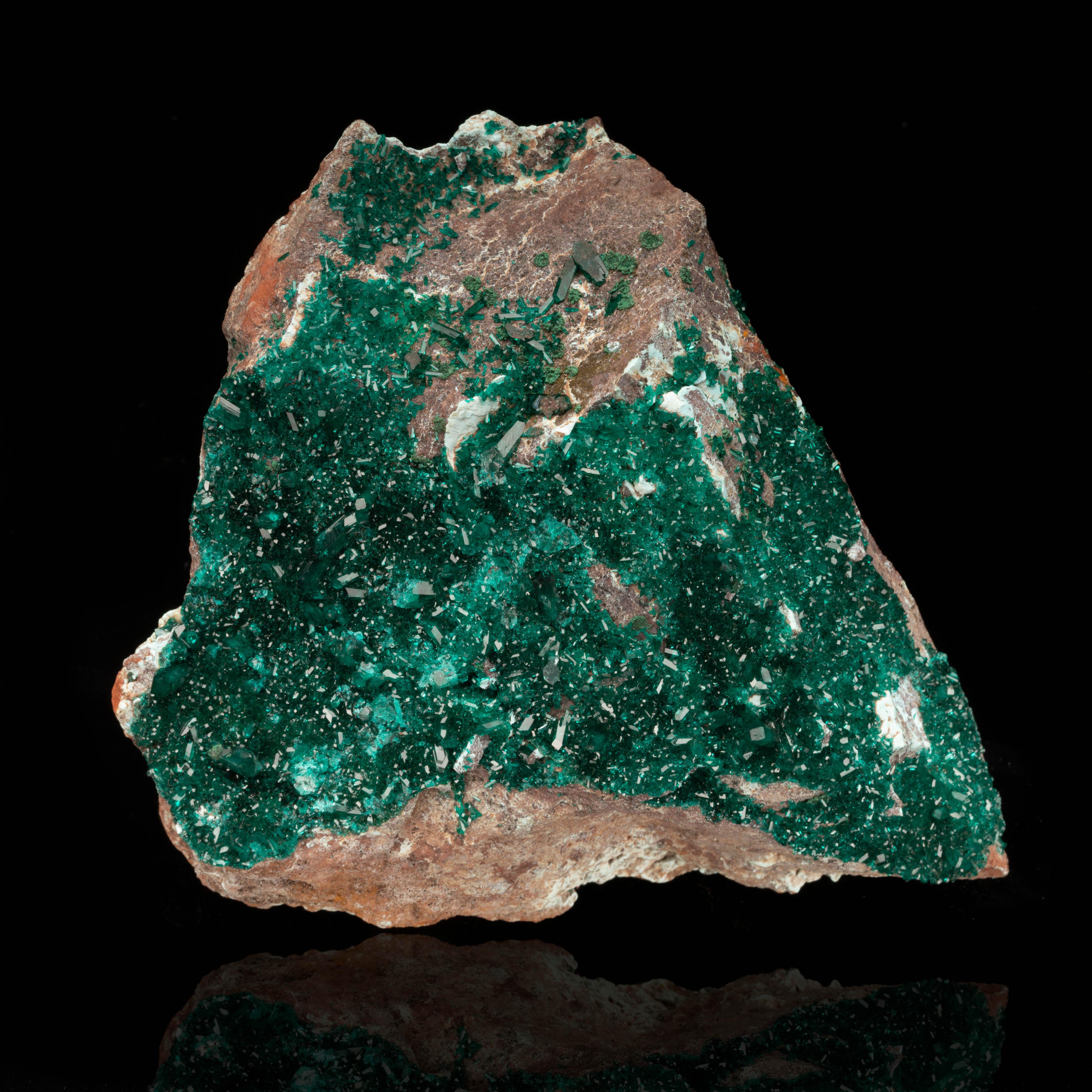 The name “dioptase” comes from Greek and references the visibility of the twin cleavage plains within the startlingly translucent, brilliantly emerald green crystals of this rare copper cyclosilicate mineral. This specimen boasts a glistening