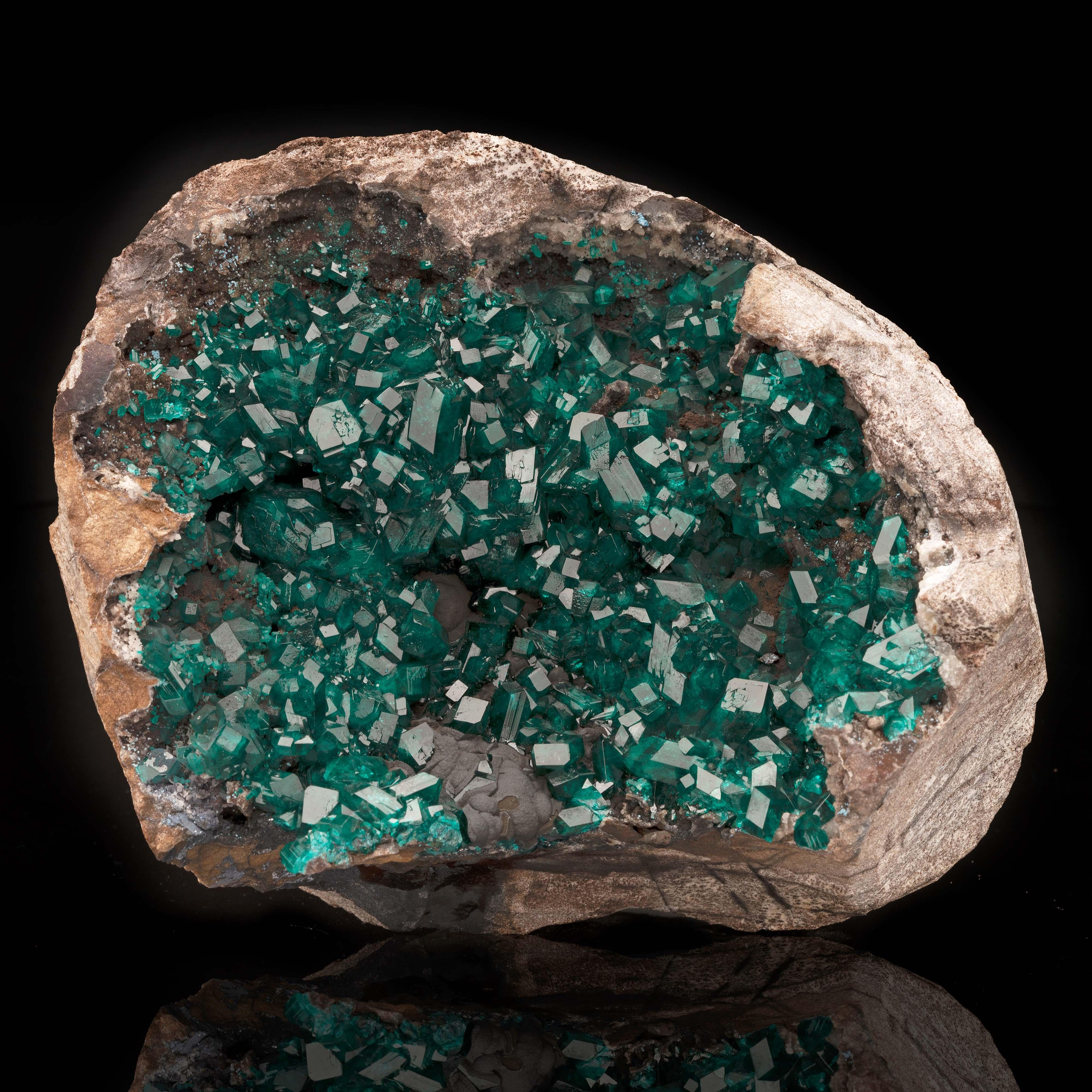 Provenant de la RDC - l'un des deux seuls endroits au monde où l'on peut trouver ce cristal rare et convoité de couleur vert émeraude à bleu-vert, l'autre étant la Namibie - ce vug - un trou naturel où se forment les cristaux - est rempli de