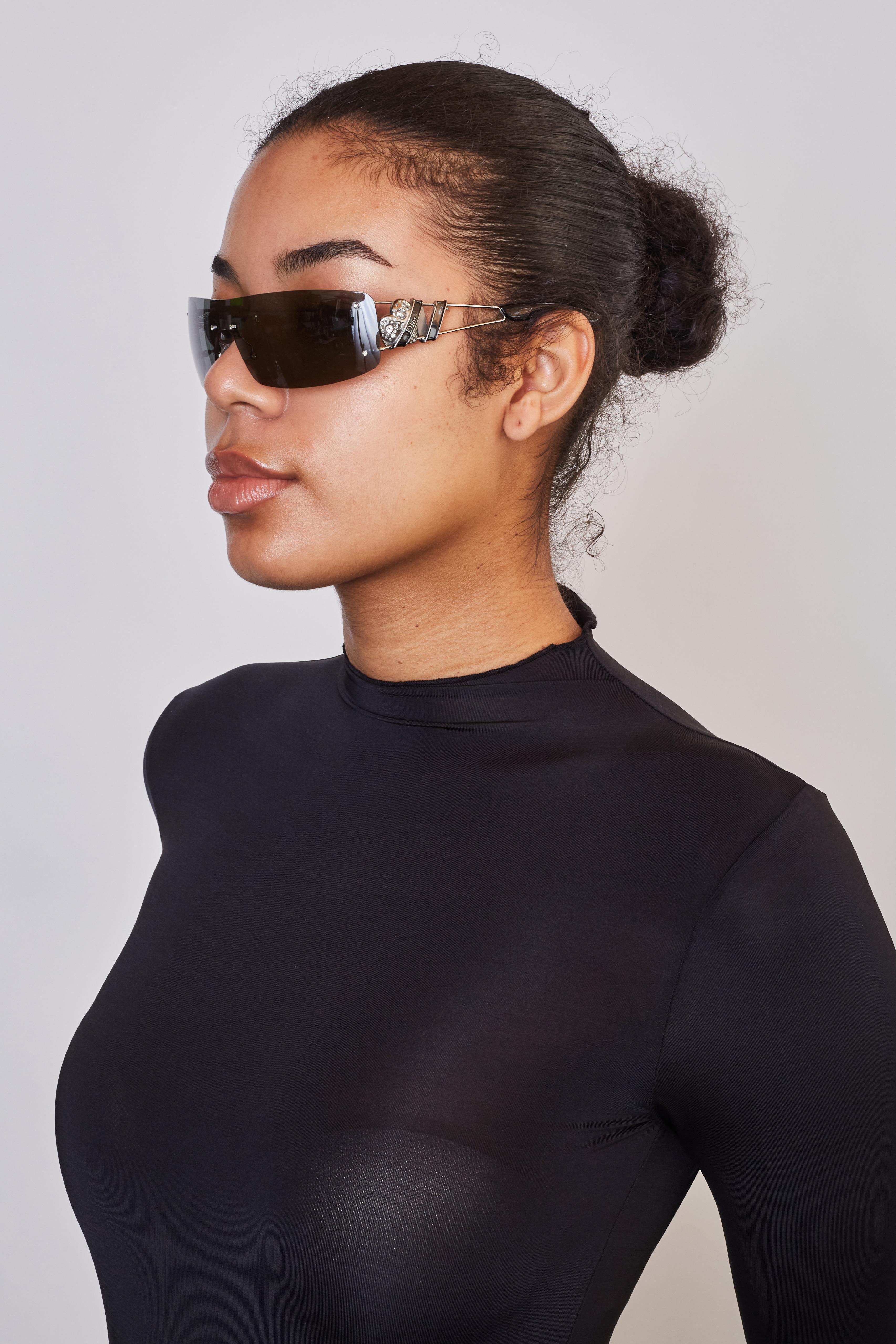 Christian Dior Shield Sunglasses
Silver Acetate
Rimless Tinted Lenses
Includes Case & Dust Cloth

Color: Gun metal
Item Code: 0210S
Size Stamp: 120
Frame Material: Acetate

Measures~
Arms: 120 mm

Condition: Good. Frame & lens show faint