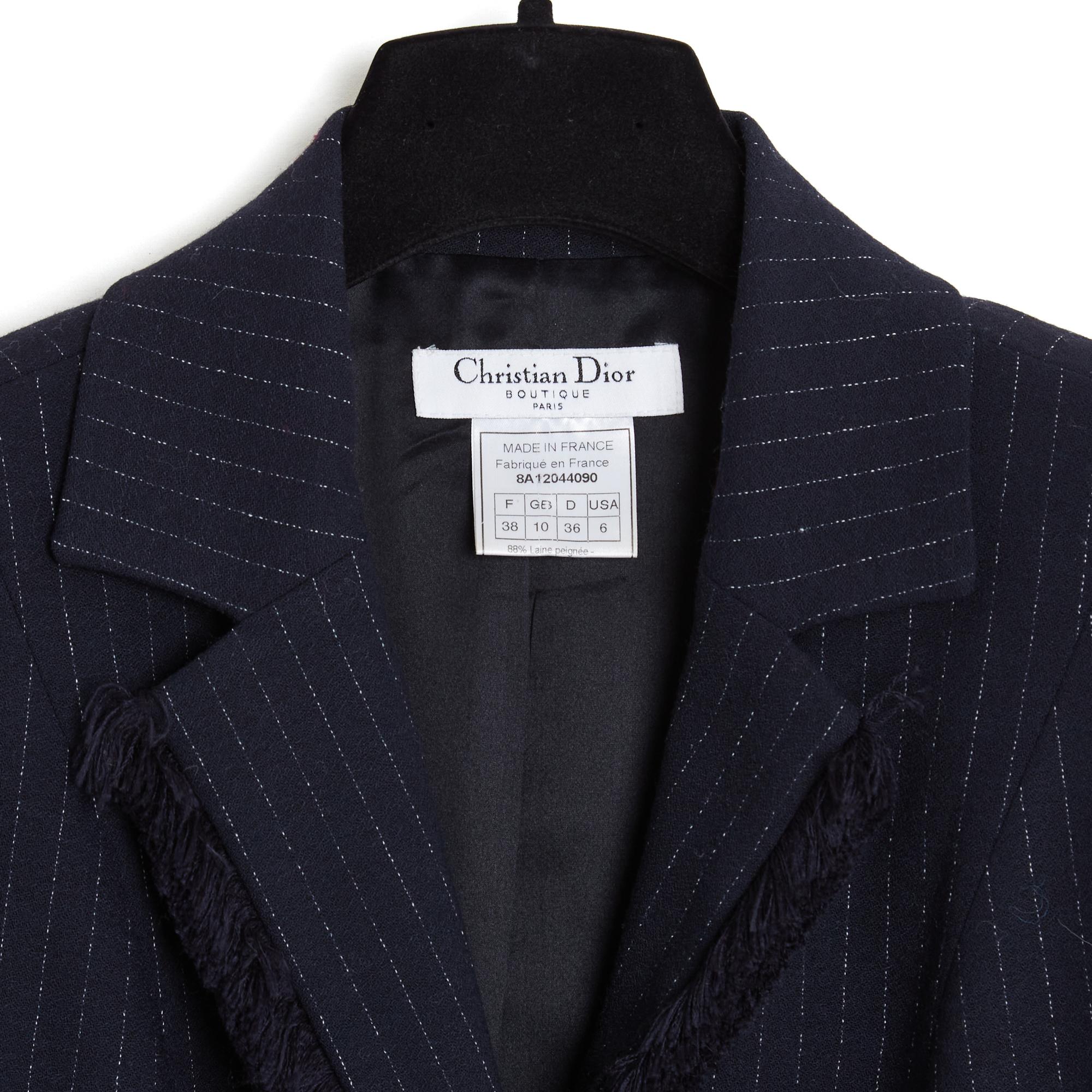 Giacca Christian Dior della collezione AW2008 di John Galliano in crêpe di lana blu navy con sottili strisce bianche, colletto dentellato chiuso da 2 bottoni dello stesso tessuto e da un bottone nascosto e bordato, come le spalle, da una frangia di