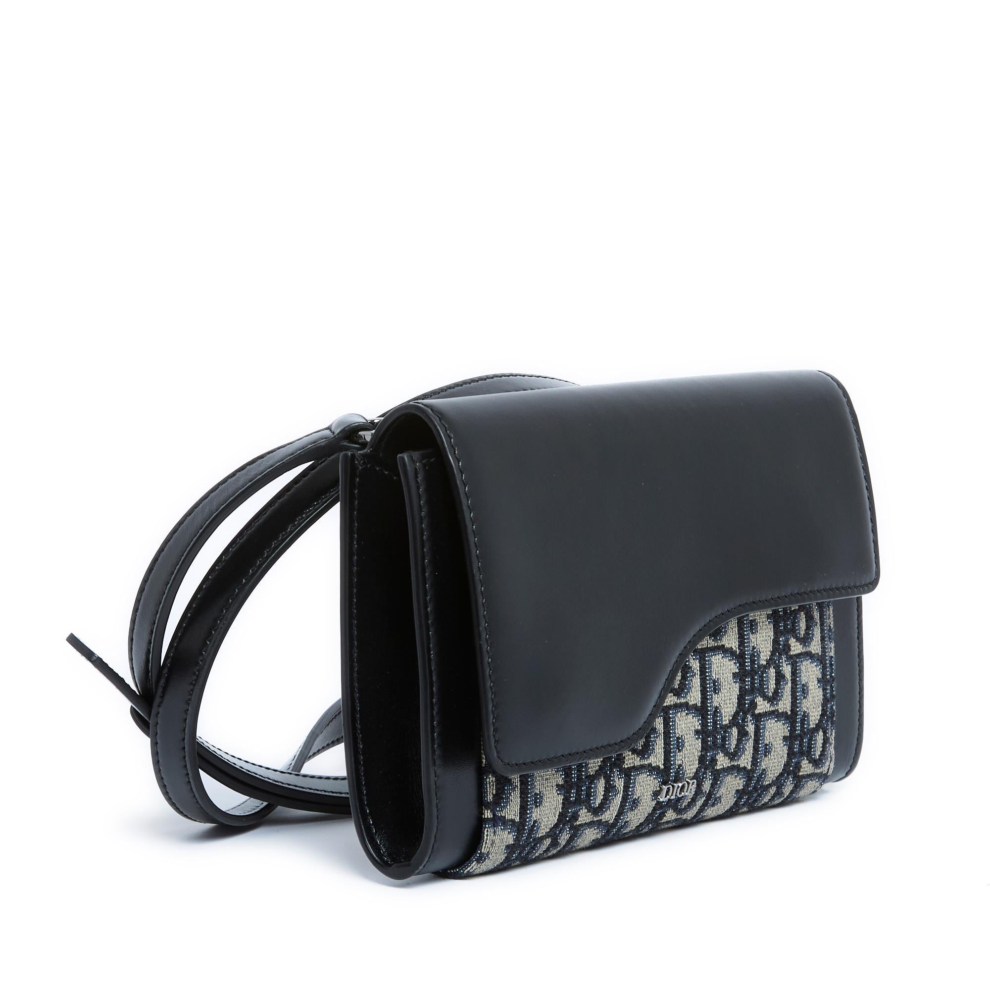 Christian Dior bag, Wallet on strap Oblique Jacquard model, in navy blue leather and blue Dior canvas, leather interior with a large compartment, a pocket for papers and 3 credit card slots, flap closed by a magnetic snap, adjustable shoulder strap