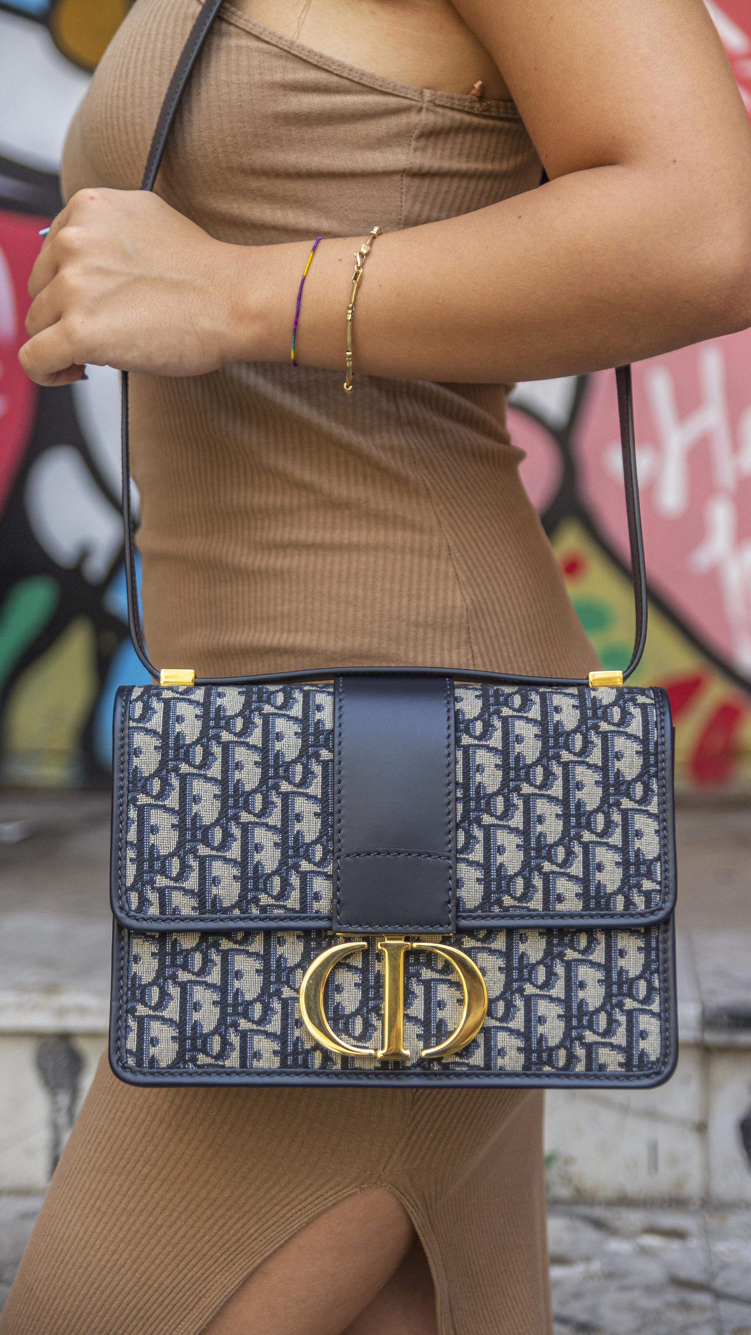 Borsa firmata Dior, linea 30 Montaigne, realizzata in tela blu in fantasia Jacquard Oblique con rifiniture in pelle tono su tono e hardware dorati. Dotata di una patta frontale con chiusura ad incastro e placchetta in metallo con logo ”CD”. Munita