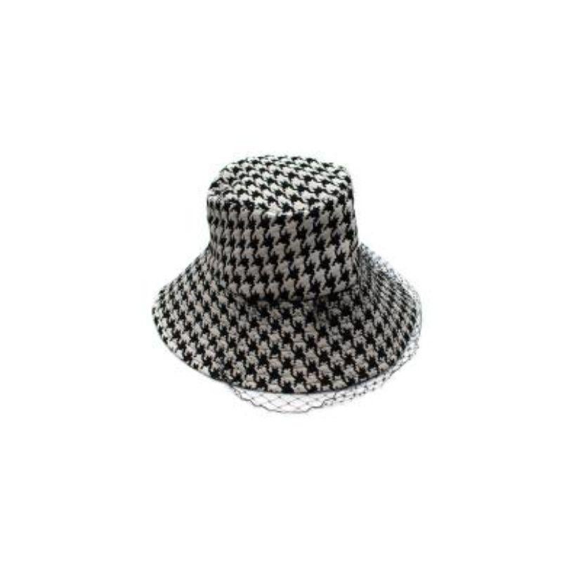 Dior 30 Montaigne Large Brim Bucket Hat with Veil

- Large brim with topstitching
- Houndstooth pattern throughout
- Veil detailing
- Signature gold bee and 'CD' embroidered in the interior

Material
100% Polyester
Interior: 100% Cotton
Veil: 100%