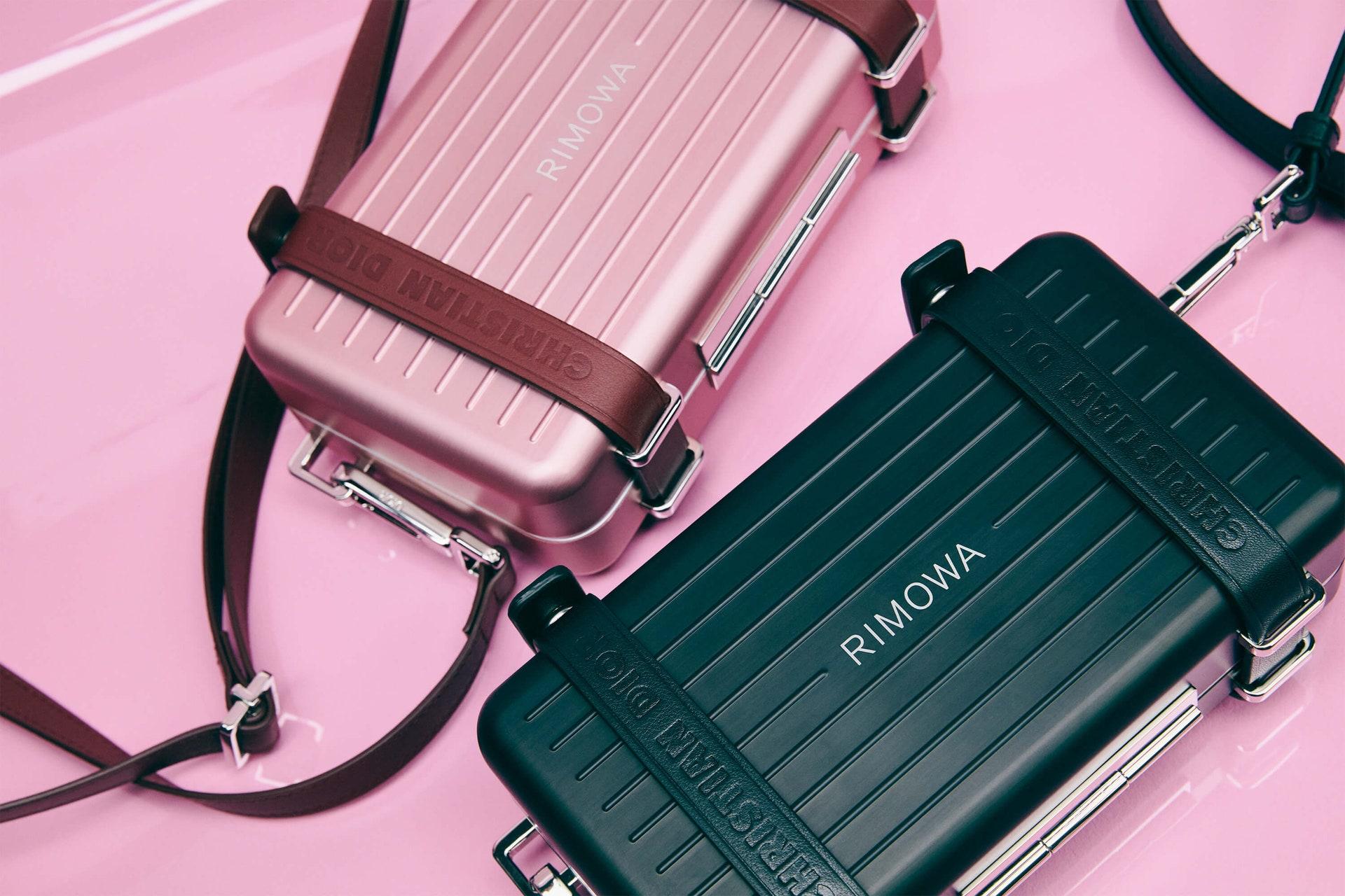 The DIOR and RIMOWA personal clutch is a compact accessory designed for easy, everyday carriage. It is made from lightweight aluminum and features 'Christian Dior' logo embossed leather straps that fasten around the bag with snap buttons. The