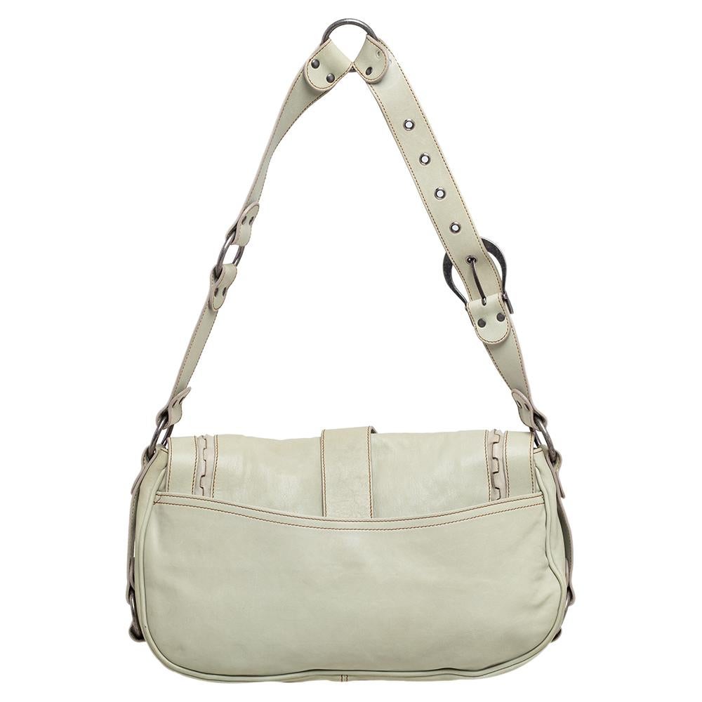 From the house of Dior, this Gaucho Double Saddle bag is an excellent blend of elegance and style. It comes in an apple green hue that is perfect for making a statement. The bag features a chunky buckle with an attached key on the front flap and a
