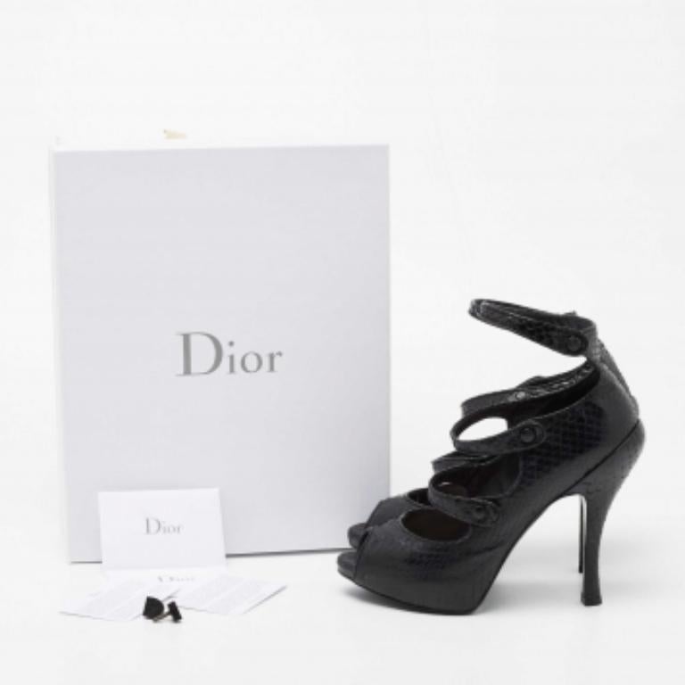 Verwöhnen Sie Ihre Füße mit diesen luxuriös gestalteten Dior-Sandalen. Sie sind aus Pythonleder gefertigt und verfügen über ein Riemenoberteil, einen Knopfverschluss und Peep-Toes. Die 13,5 cm hohen Absätze und das Plateau dieses Paares verleihen