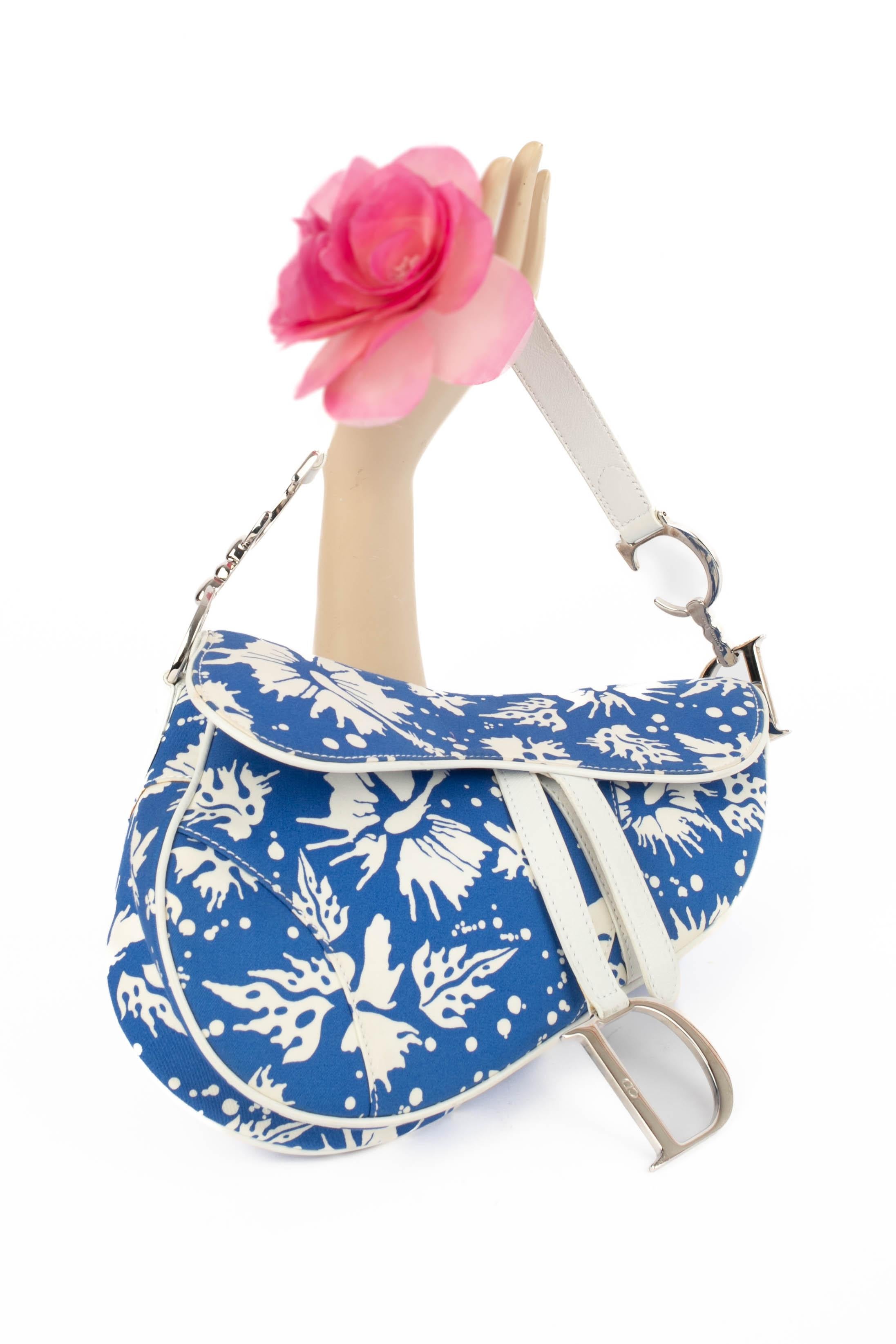 DIOR -(Made in Italy) Blaue 'Saddle Surf' Tasche aus Baumwolle mit weißem Druck und passenden Lederelementen. Klettverschluss auf einer Klappe. Spring-Summer Collection 2004 unter der künstlerischen Leitung von John Galliano.

Bedingung:
Sehr guter