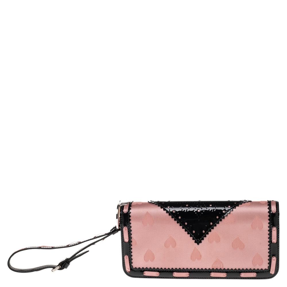 Stylish and elegant, this D'Trick Clutch by Dior is stunning and great for a host of occasions. It has been crafted from patent leather and satin and carries lovely shades of beige & black. The clutch is styled with brogue detailing, a wristlet, a D