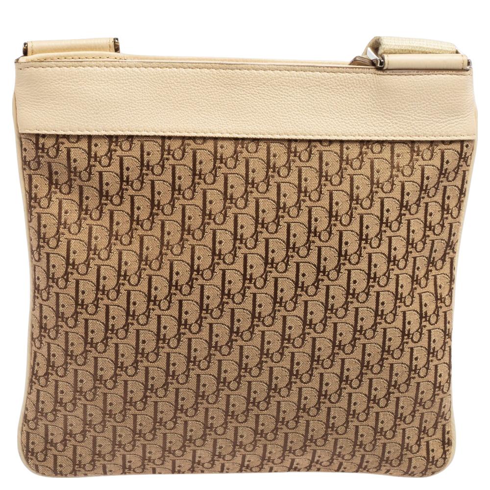 Style and functional ease combine to form this messenger bag from Dior. Crafted from Oblique jacquard canvas and beige leather, the bag is added with a front brand plaque and an adjustable shoulder strap. It is complete with a fabric-lined interior.