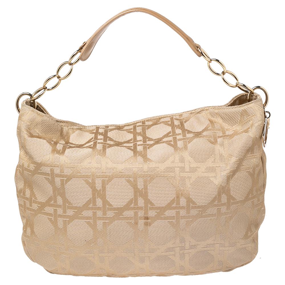 Dior bags never go out of style, this Lady Dior hobo is one example. Crafted from soft canvas and leather with the cannage pattern, this hobo features a chain-link and leather handle, Dior letters charms, and a relaxed shape. The fabric-lined