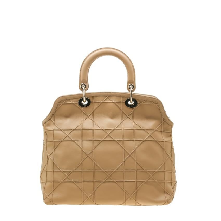 Fashioned from Cannage leather, this bag is a reliable accessory addition. The two handles are easy to hold and the leather and nylon lined interior will keep your essentials safe. Coming from the house of Dior, this beige piece will highlight your