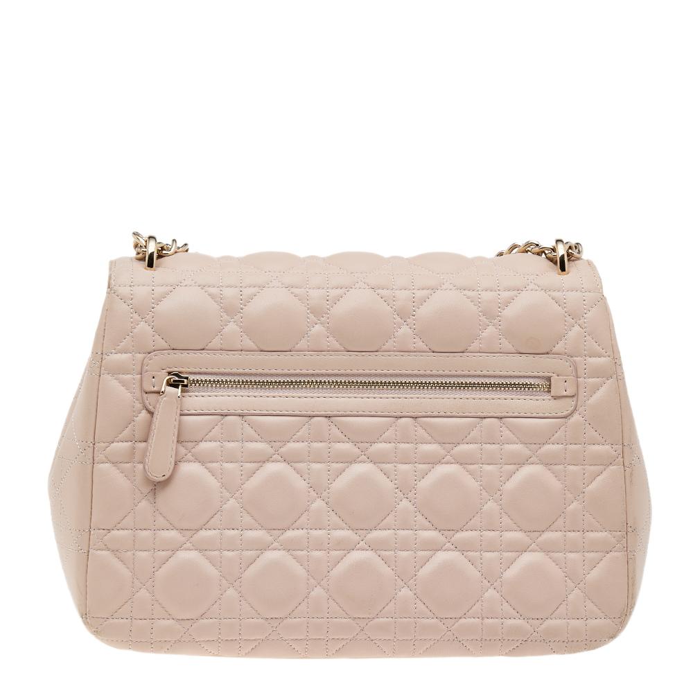 Flap bags like this Miss Dior will never go out of style. Crafted from leather, this Dior bag features a beige Cannage quilted exterior and a chain-link strap. The front flap has a gold-tone push lock that opens to a leather-lined interior with