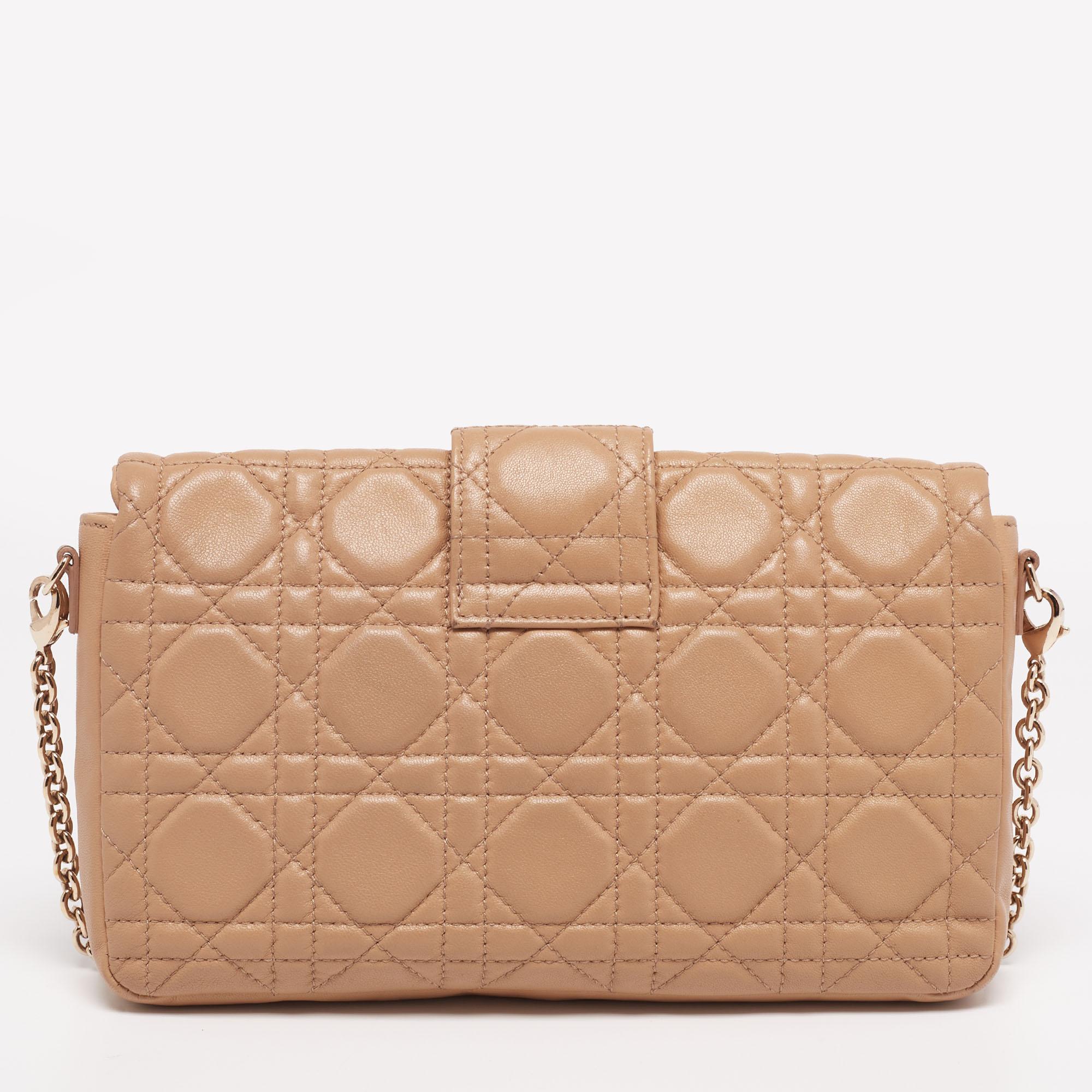 Dior's luxurious craftsmanship is reflected in this Miss Dior Promenade clutch. Elegantly crafted from leather, the bag is highlighted with the signature Cannage motif and features a chain shoulder strap, a branded lock on the flap, and gold-tone