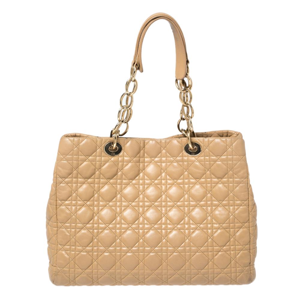 Impressive and high on style, this Lady Dior shopper tote from Dior comes made from beige leather and features the signature cannage quilted pattern on the exterior. It has dual top handles carrying attached 'DIOR' letter charms and a nylon-lined
