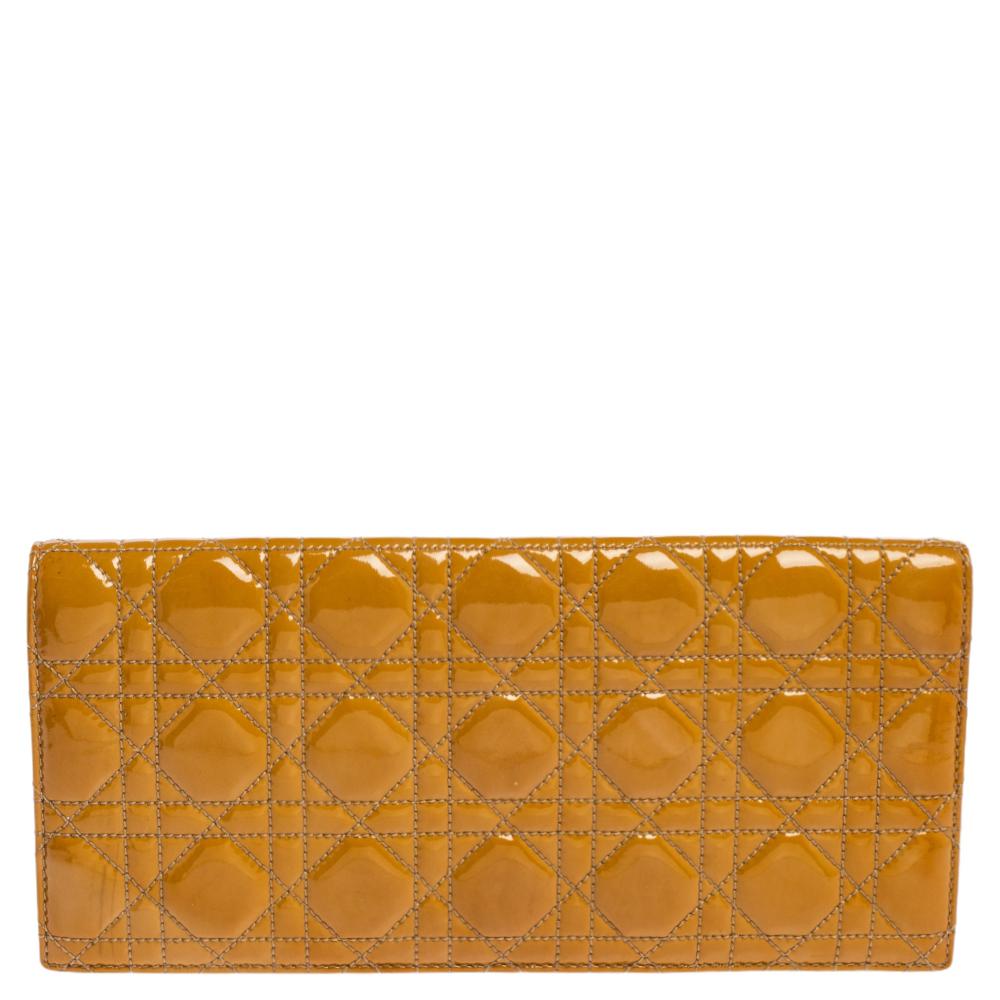 This Lady Dior clutch has been crafted in Italy from patent leather and it carries the brand's signature Cannage quilt. It is equipped with an interior having ample space for your essentials. The gorgeous piece is complete with a gold-tone chain and