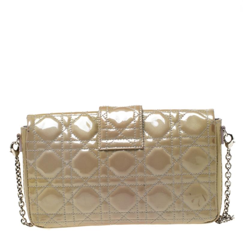 This stunning Miss Dior Promenade pouch is a compact version of the Miss Dior bag. Dazzling in a gorgeous beige shade, the bag is crafted from patent leather and features the signature Cannage pattern on the exterior, a detachable chain-link strap