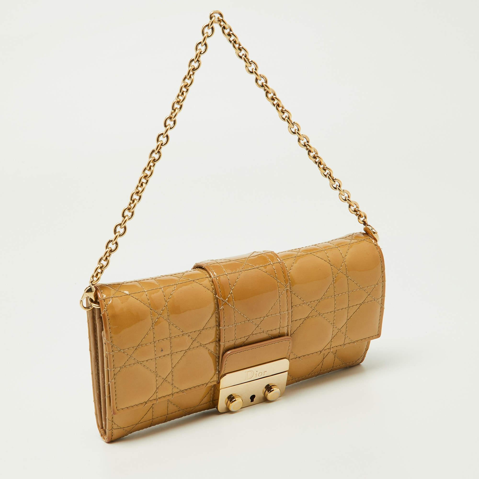 Dazzling in a gorgeous beige shade, this Dior WOC is crafted from patent leather in their Cannage pattern and designed with a front flap that is detailed with a gold-tone lock. The leather and nylon-lined interior houses a zip pocket, slip pockets,