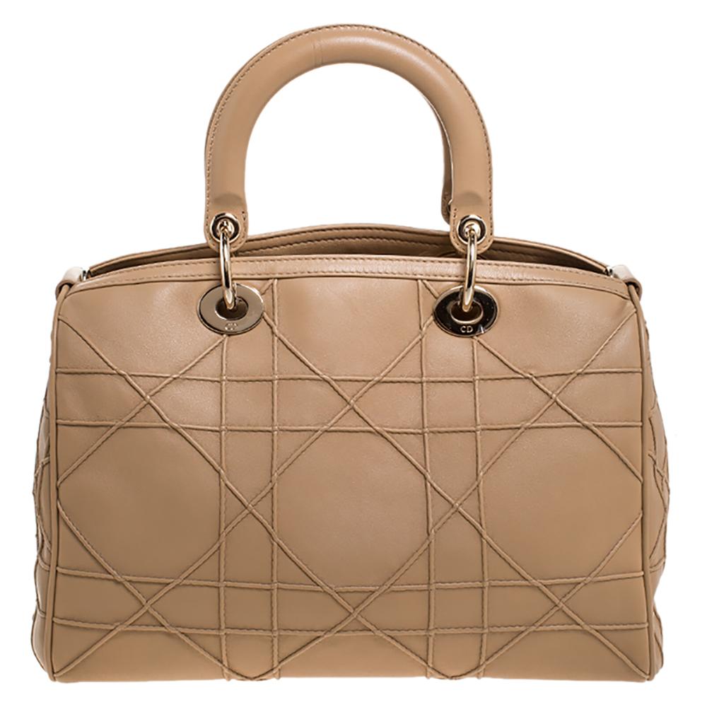 This Granville Polochon from Dior is a bag that every fashionista craves to possess. The bag has been crafted from cannage quilted leather and it carries a sleek beige exterior. It is equipped with a nylon interior, two rolled handles with a