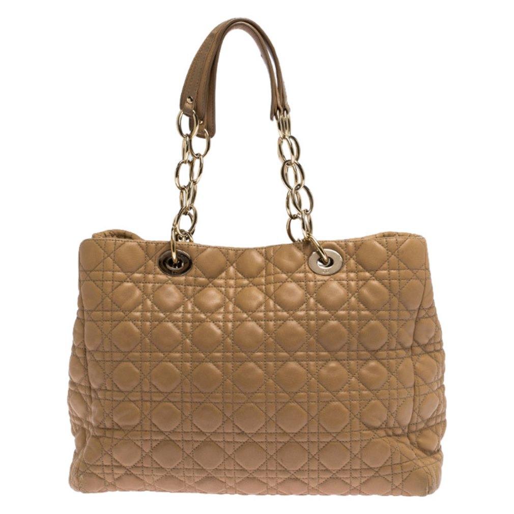 This shopper tote from Dior is a timeless piece. The bag is crafted from luxurious beige quilted leather and has the cannage pattern. It features double top handles, protective feet at the bottom and Dior letter charm in gold tone. A buttoned