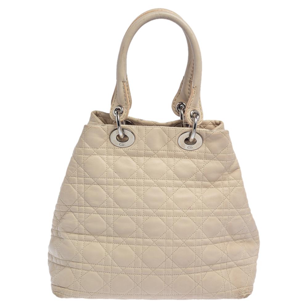 The Lady Dior tote is a Dior creation that has gained recognition worldwide and is today a coveted bag that every fashionista craves to possess. This beige tote has been crafted from soft leather and it carries the signature Cannage quilt. It is