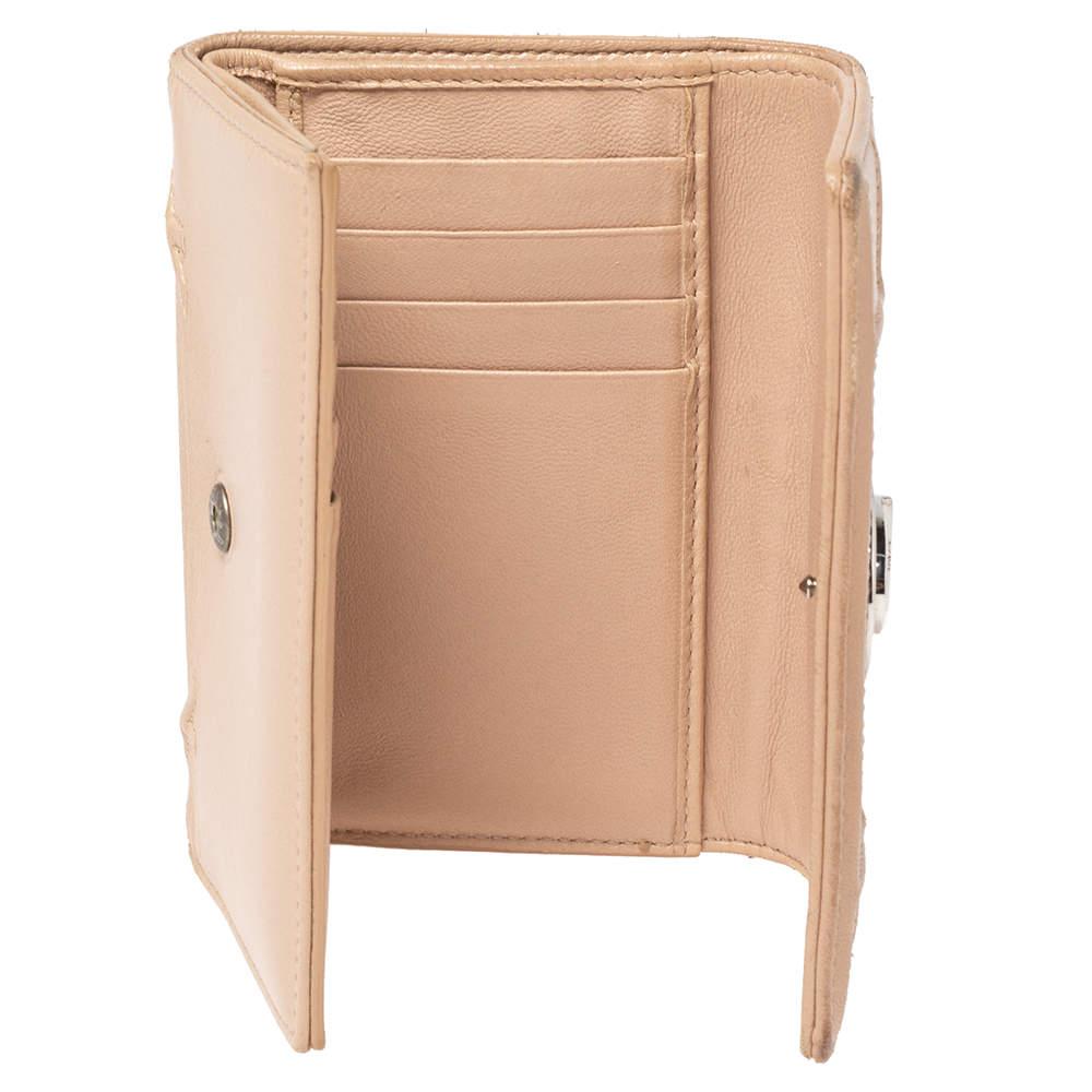 Match your Dior bags with the elegant Diorama wallet. Crafted in beige-hued leather, this Diorama wallet features the signature lock in silver-tone hardware. The press lock opens to an organized interior to neatly carry your necessities. 