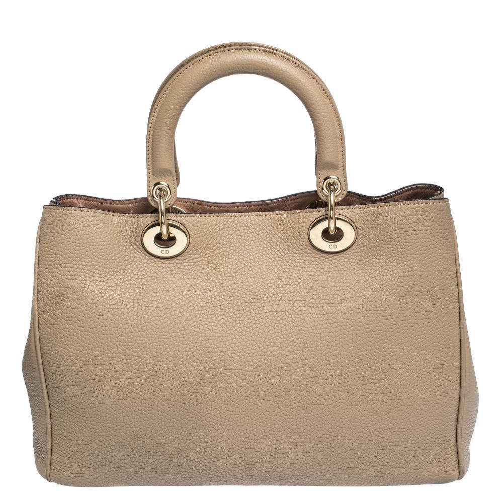 Dior takes pride as the creator of haute couture. The luxury brand presents this distinguished Diorissimo tote that brings in some cheer on a dull day. Neatly constructed with sturdy leather, this beige bag has an accommodating interior that’s lined