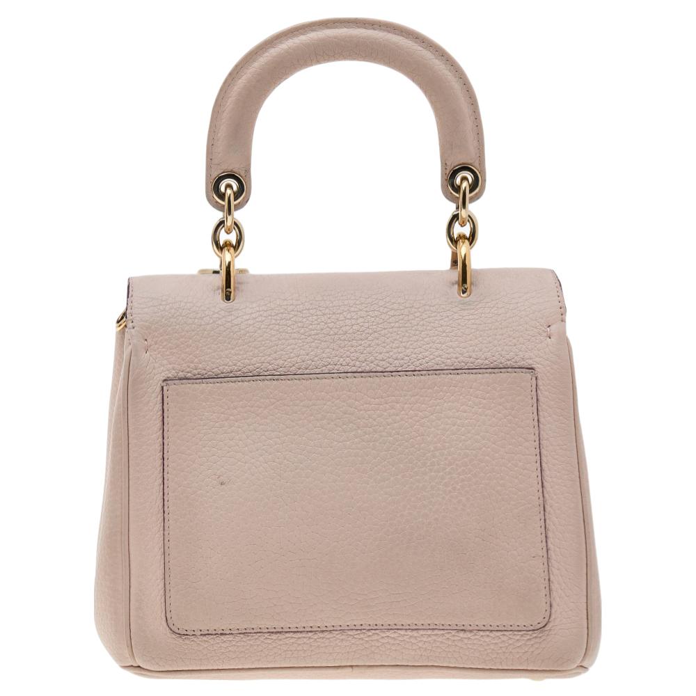 This Be Dior bag from the house of Dior is sure to add sparks of luxury to your wardrobe! It is crafted from leather and features a chic silhouette. It flaunts a single rolled top handle with attached 'DIOR' letter charms and comes equipped with