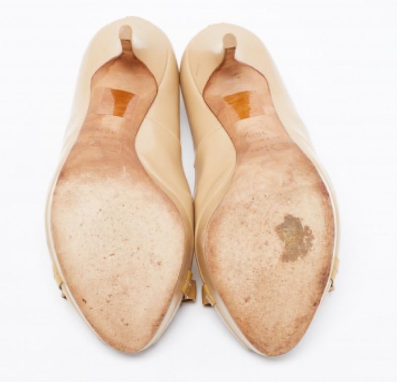 Dieses Paar Pumps von Dior soll der Trägerin das Gefühl geben, etwas Besonderes zu sein. Er ist aus Leder gefertigt, mit einer Schleife auf der Zehenspitze verziert und mit goldfarbener Hardware ausgestattet.  Die 12,5 cm hohen Absätze und das