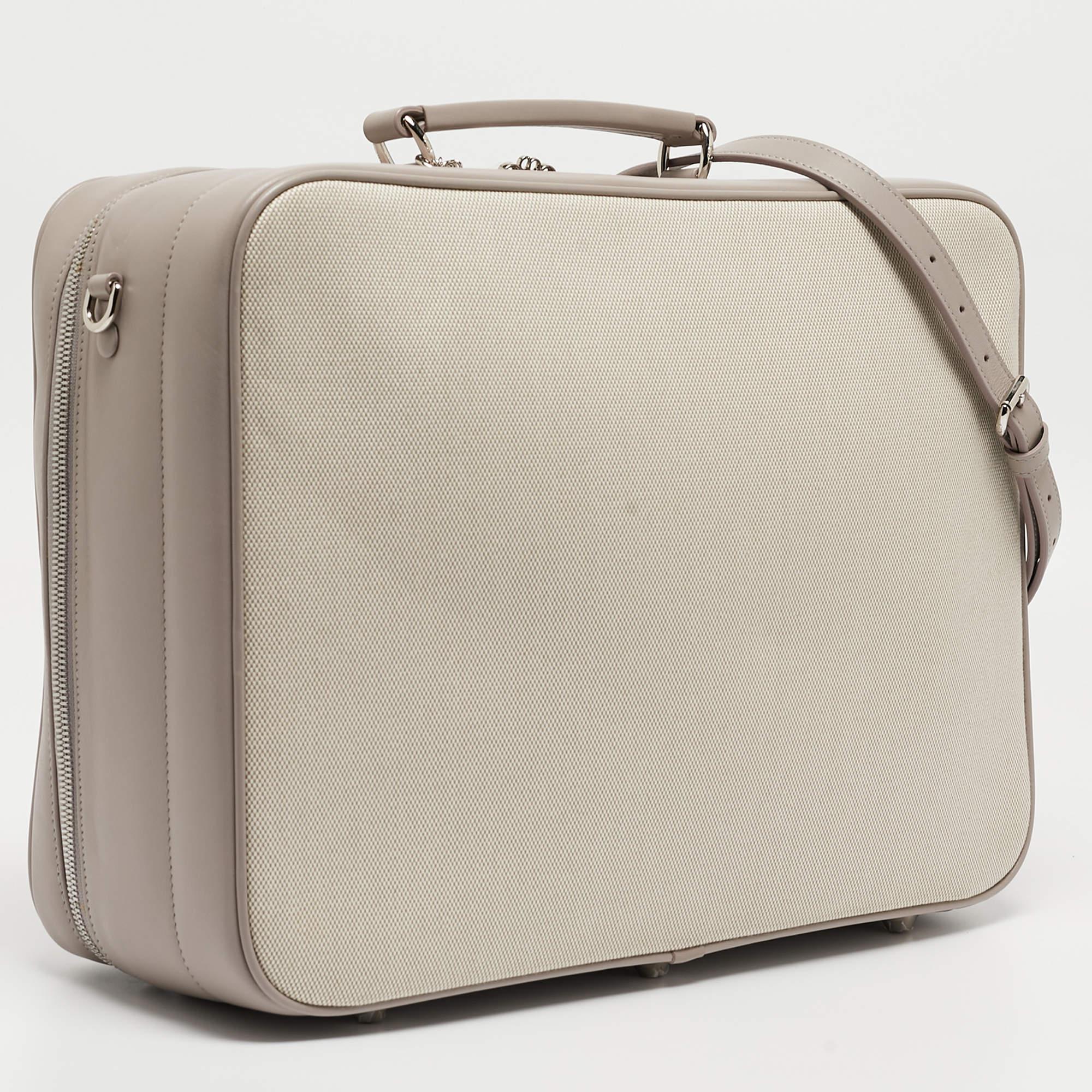 La valise à langer Dior respire l'élégance avec sa fusion sophistiquée de toile beige et de touches de cuir lilas. L'intérieur spacieux est conçu pour une organisation efficace, tandis que le logo emblématique de Dior ajoute une touche de luxe.