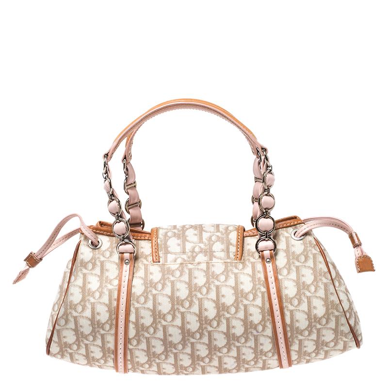 Head to your next social event carrying this chic Romantique Trotter bag from Dior. Designed in a Diorissimo-coated canvas body, this bag is finished with brightly-colored leather trims, silver-tone hardware and a front flap detailed with a cute
