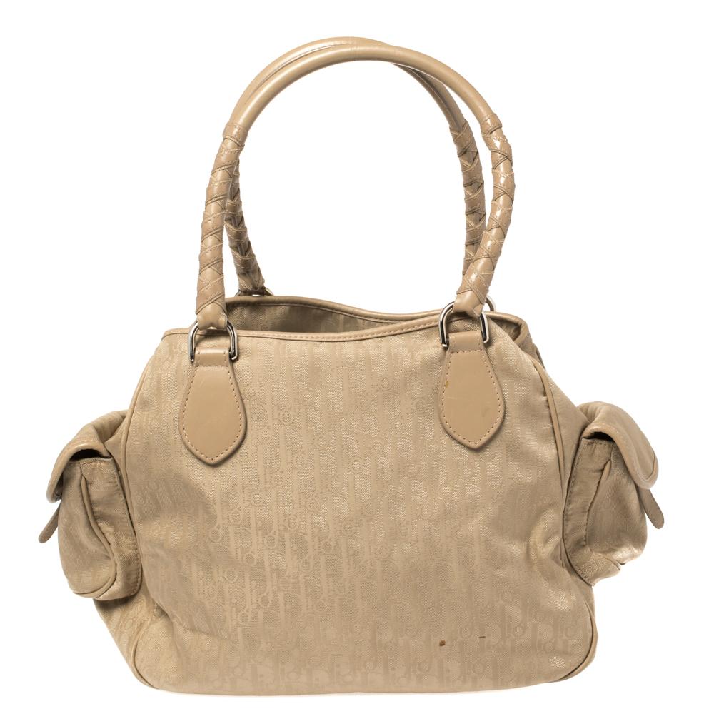 Minimally stylish and high on durability, this Dior tote will be the perfect pal to your daily errands! It has been crafted from the signature oblique canvas and leather and designed with two front pockets and a single pocket on both sides. It