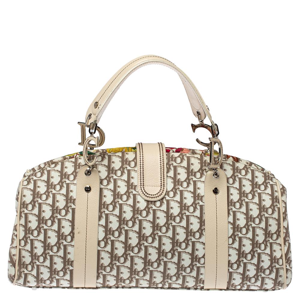 Start the summer season in style when you carry this adorable bag by Dior. It is crafted from signature Oblique coated canvas and leather trims. This satchel is accented with colorful floral embroidery on the front, silver-tone hardware, and short