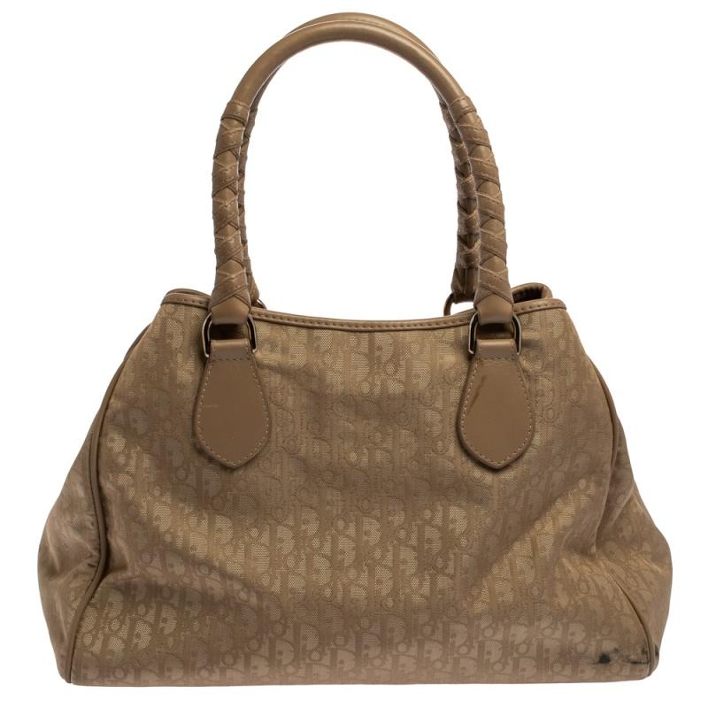 Carry this Lovely tote by the house of Dior. Crafted from signature Oblique nylon and leather, this bag is equipped with two rolled handles. It is accented with a Dior charm. Another great feature is the magnetic snap lock located on the top of the