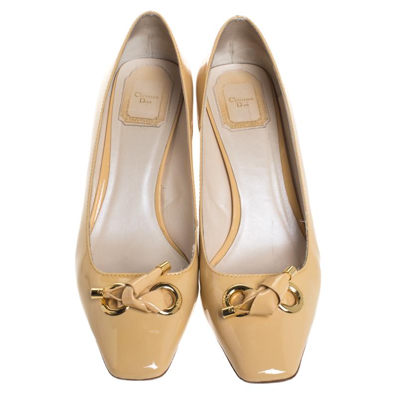 Add tons of style to your look by donning these patent leather pumps. This pair of Dior pumps have a matching bow detail on the square-toe vamps. These beige pumps are a smart pick for everyday use or for a special occasion.

Includes: Original Box,